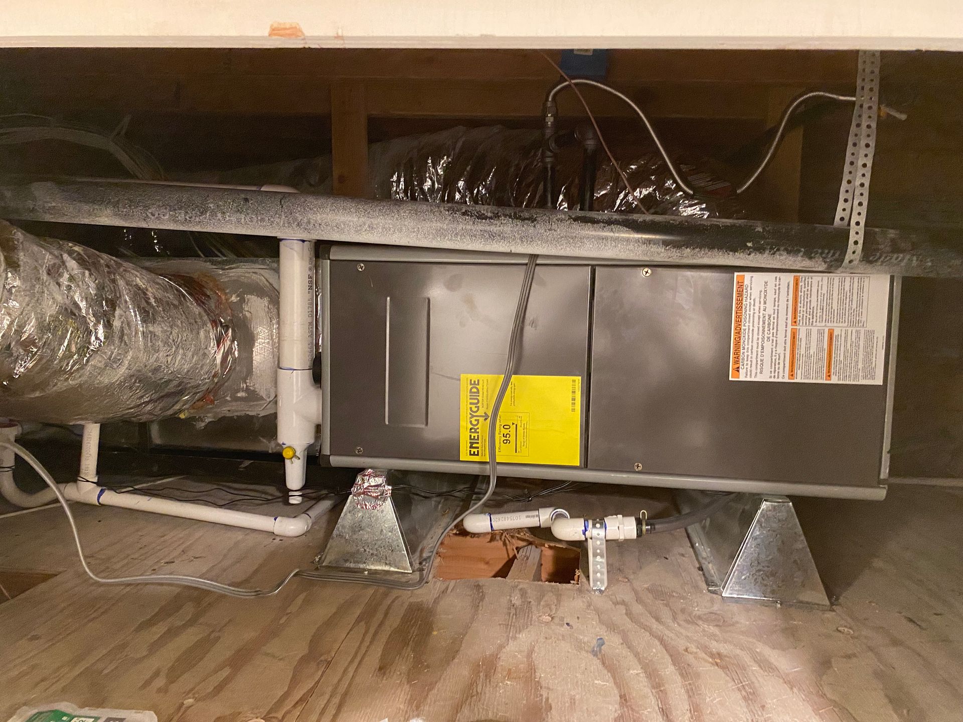 An air conditioner is sitting under a ceiling in a room.