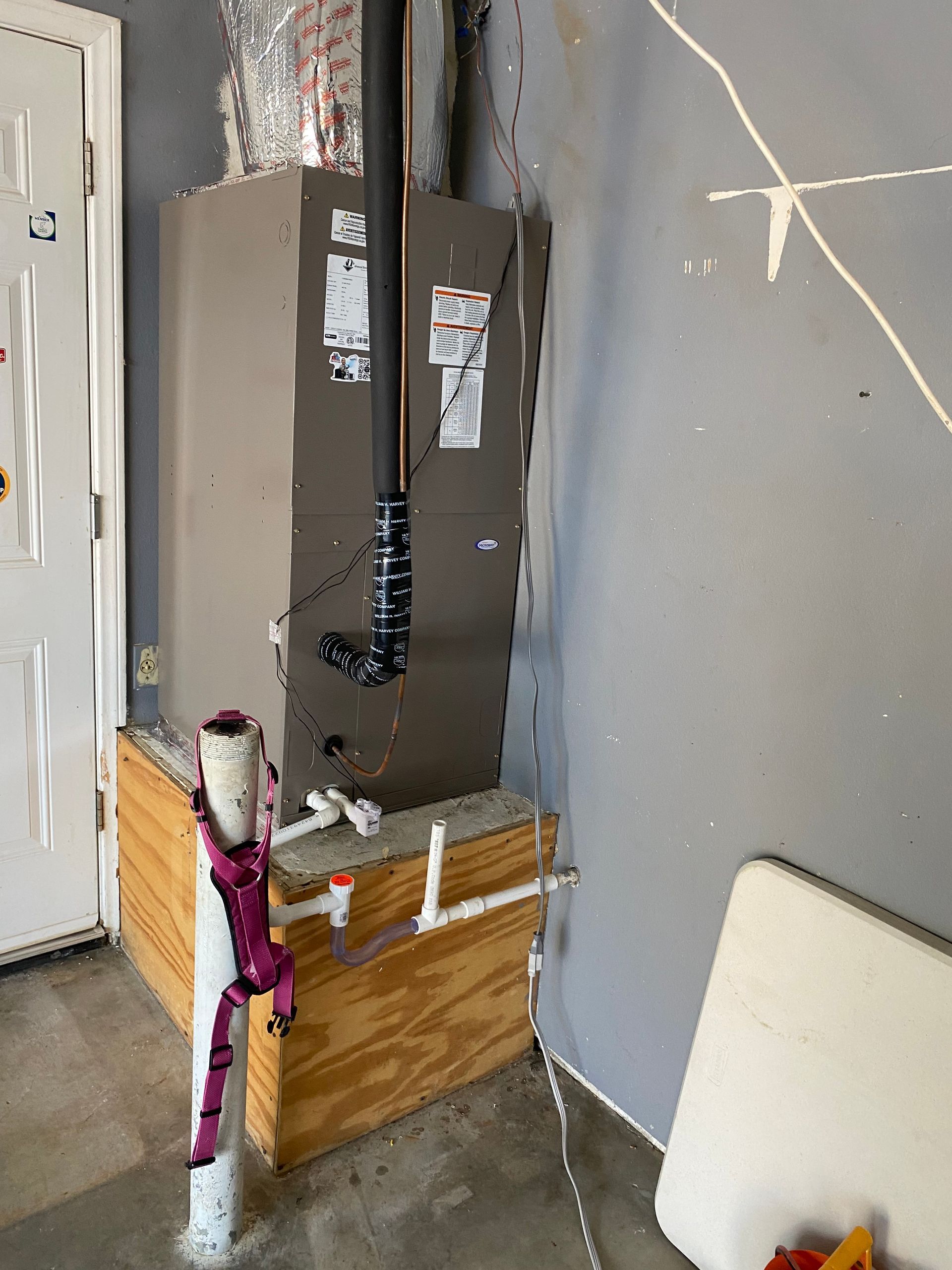 A room with a refrigerator and a furnace in it.