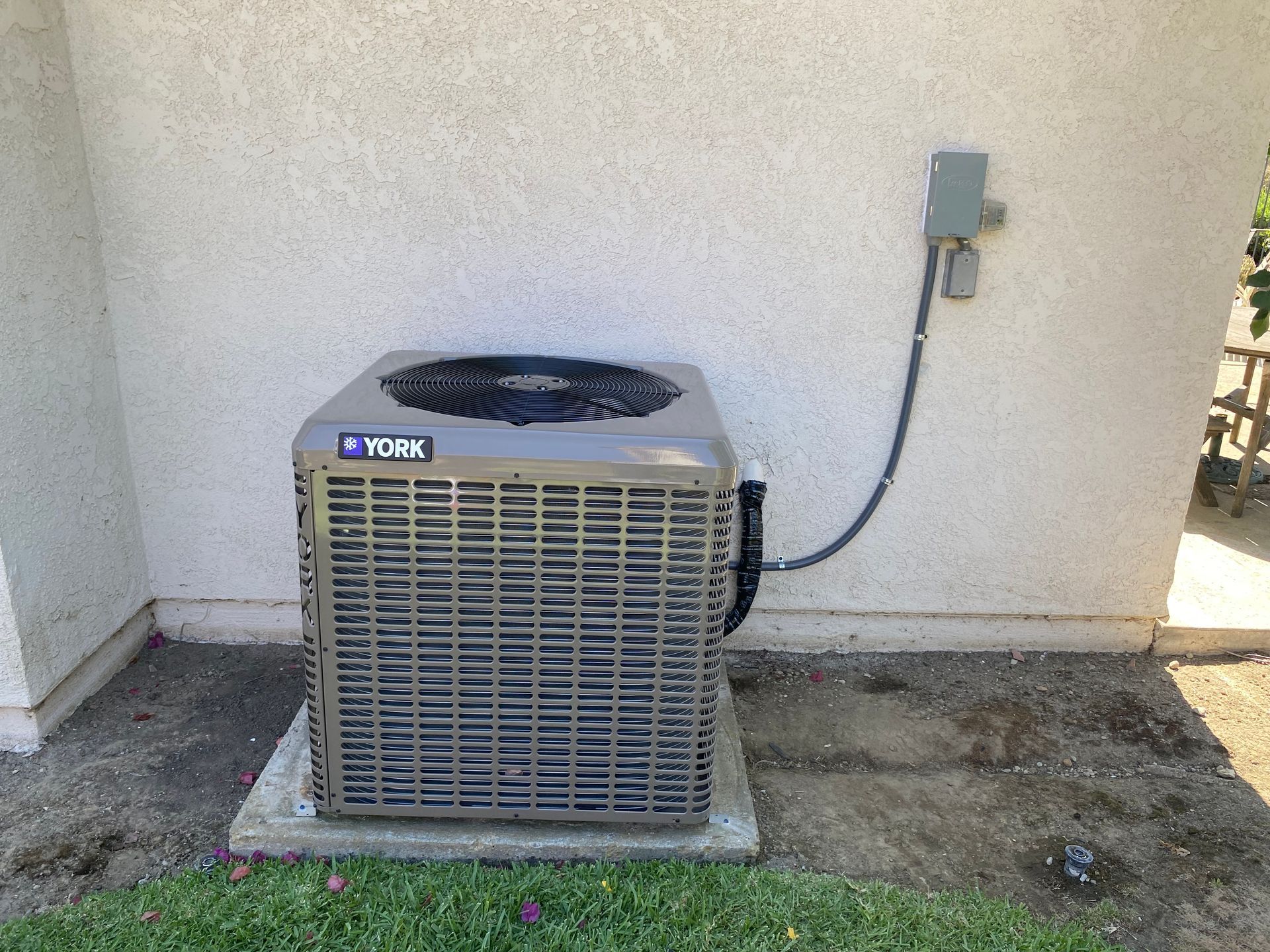 An air conditioner is sitting on the side of a building.