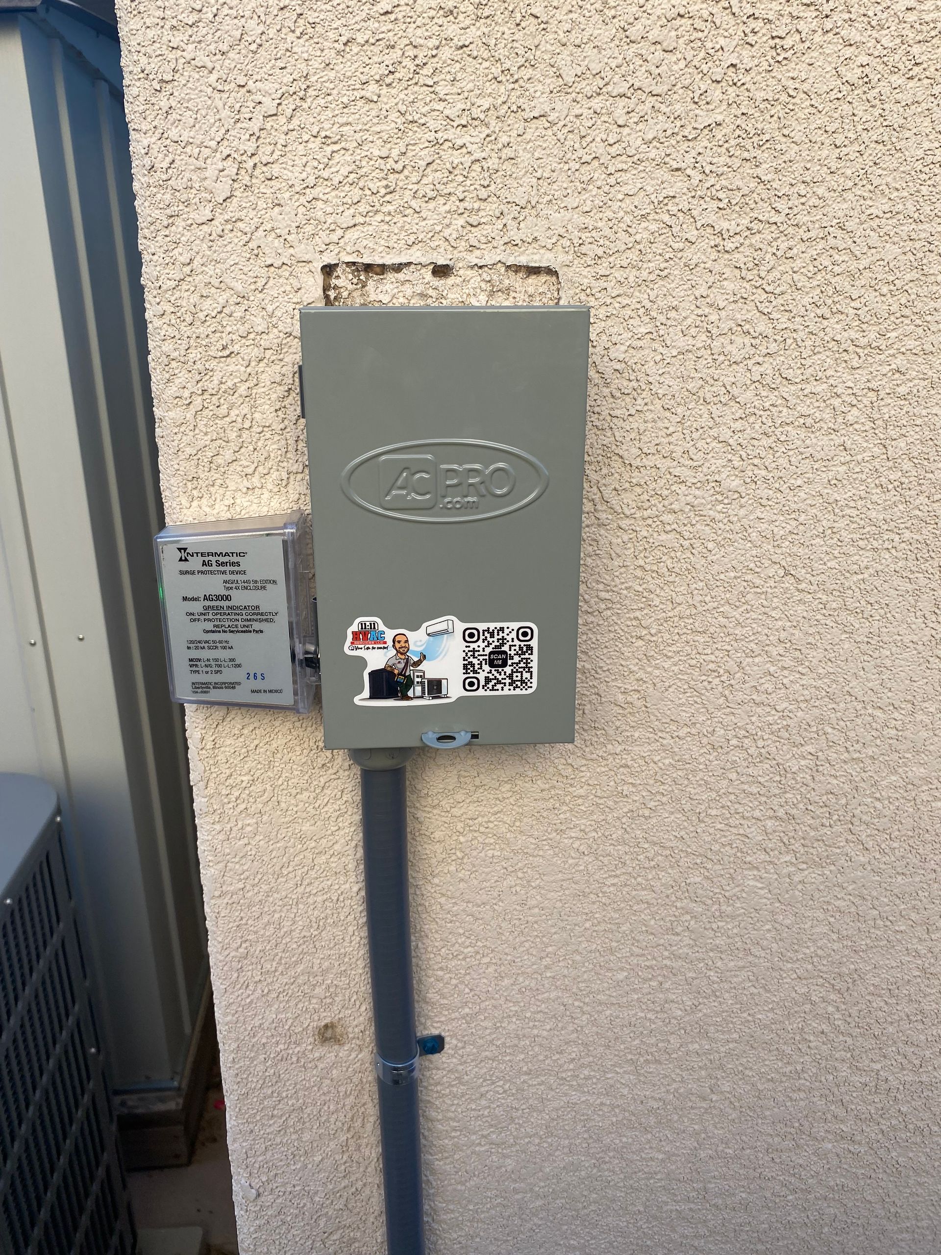 A gray box is attached to the side of a building.