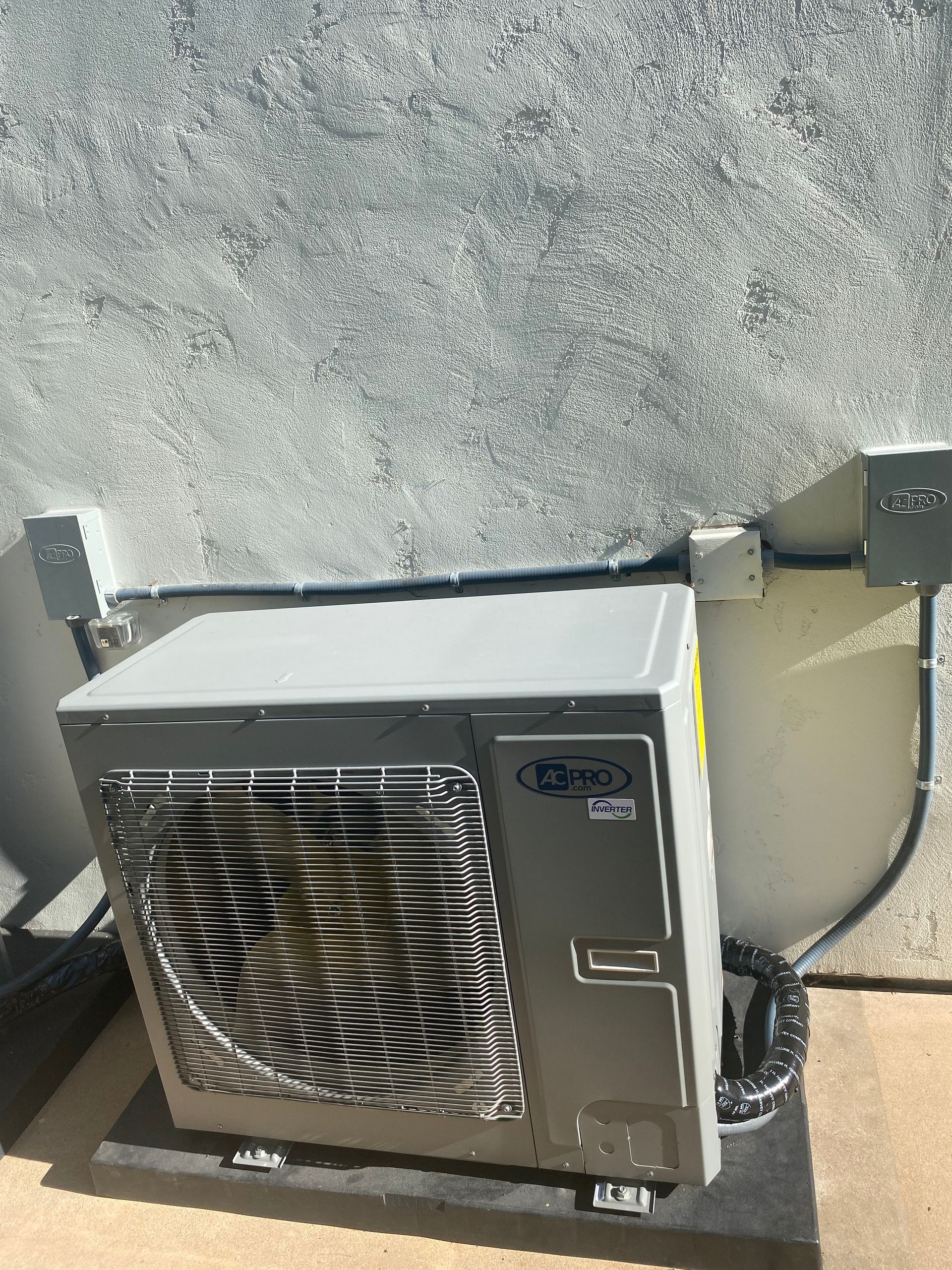 A large air conditioner is sitting on top of a concrete surface.