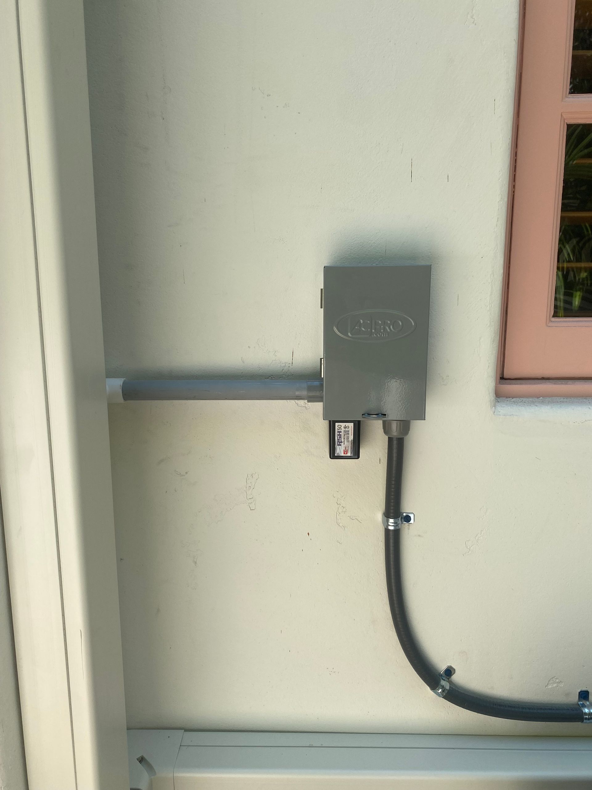 A box on the side of a building with a window in the background