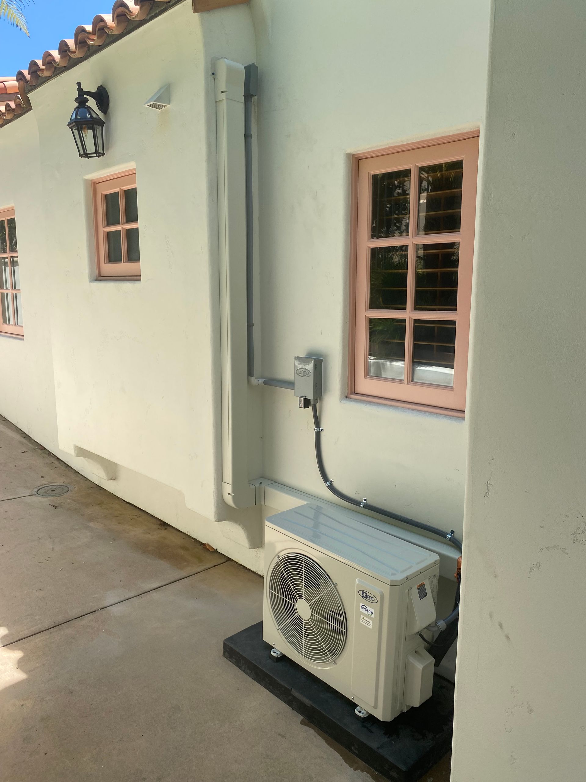 A white house with a fan on the side of it