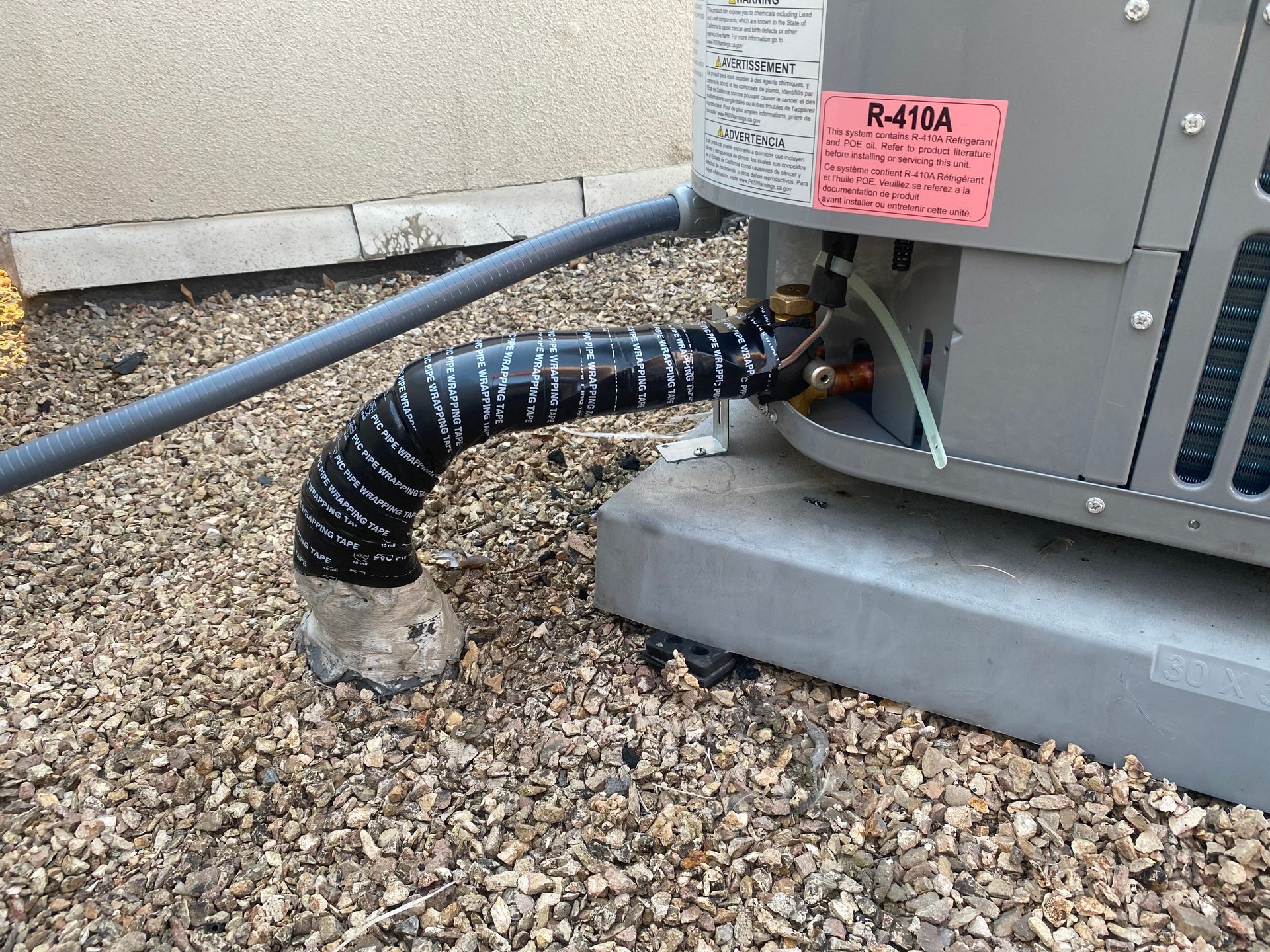 A close up of a hose attached to an air conditioner.