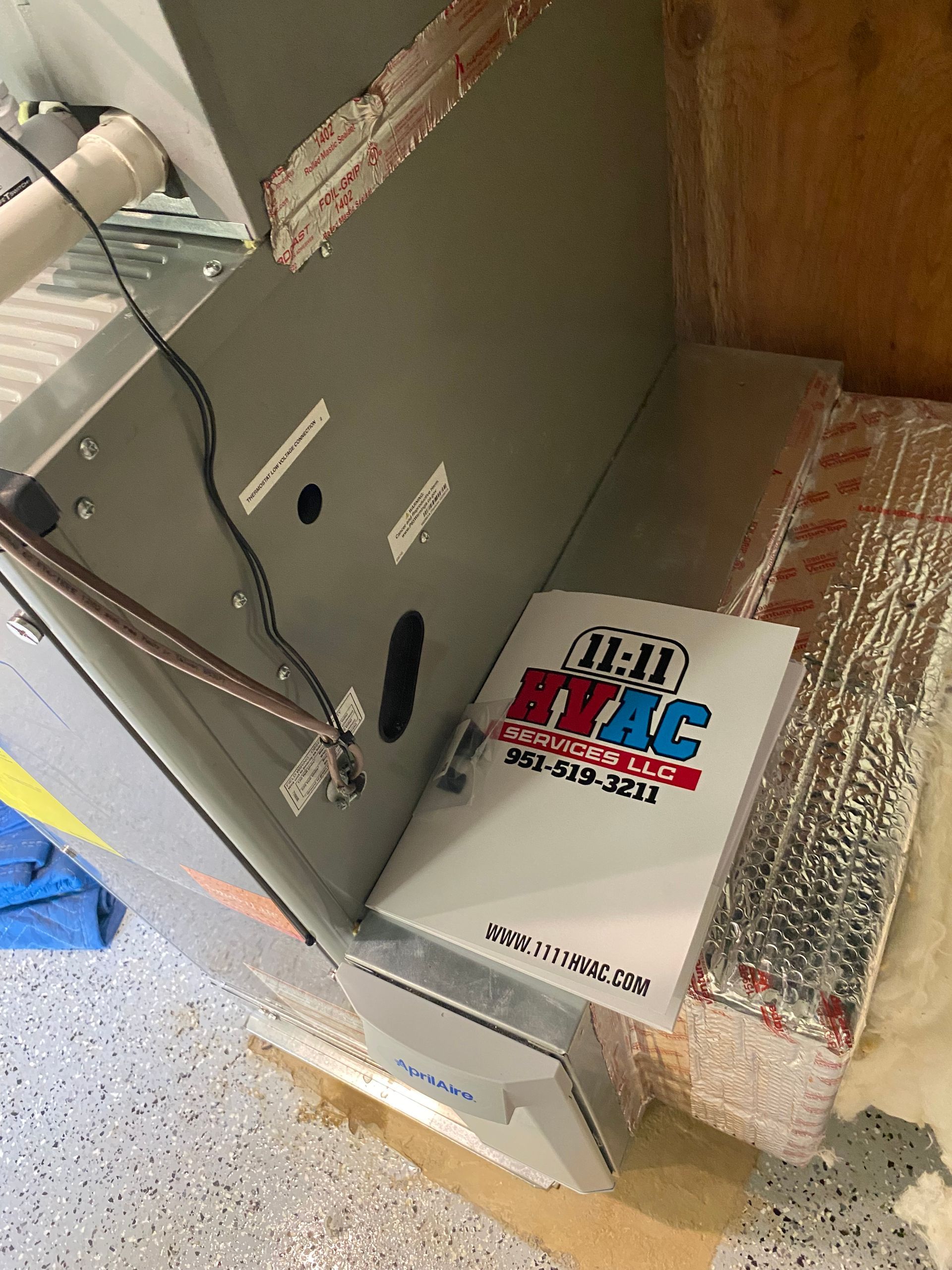 A book is sitting on the floor next to a furnace.