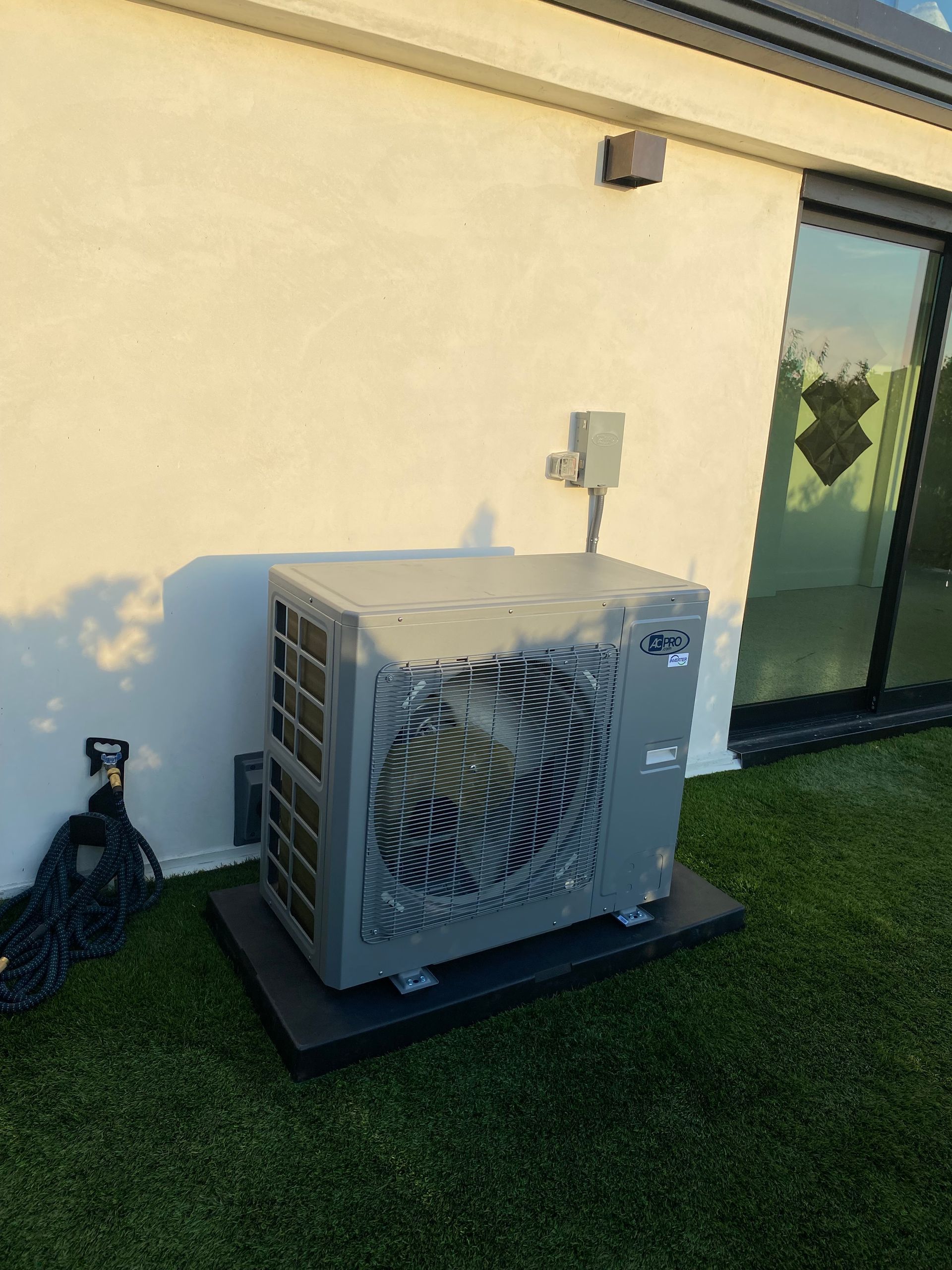 A broken air conditioner is sitting on the side of a building.