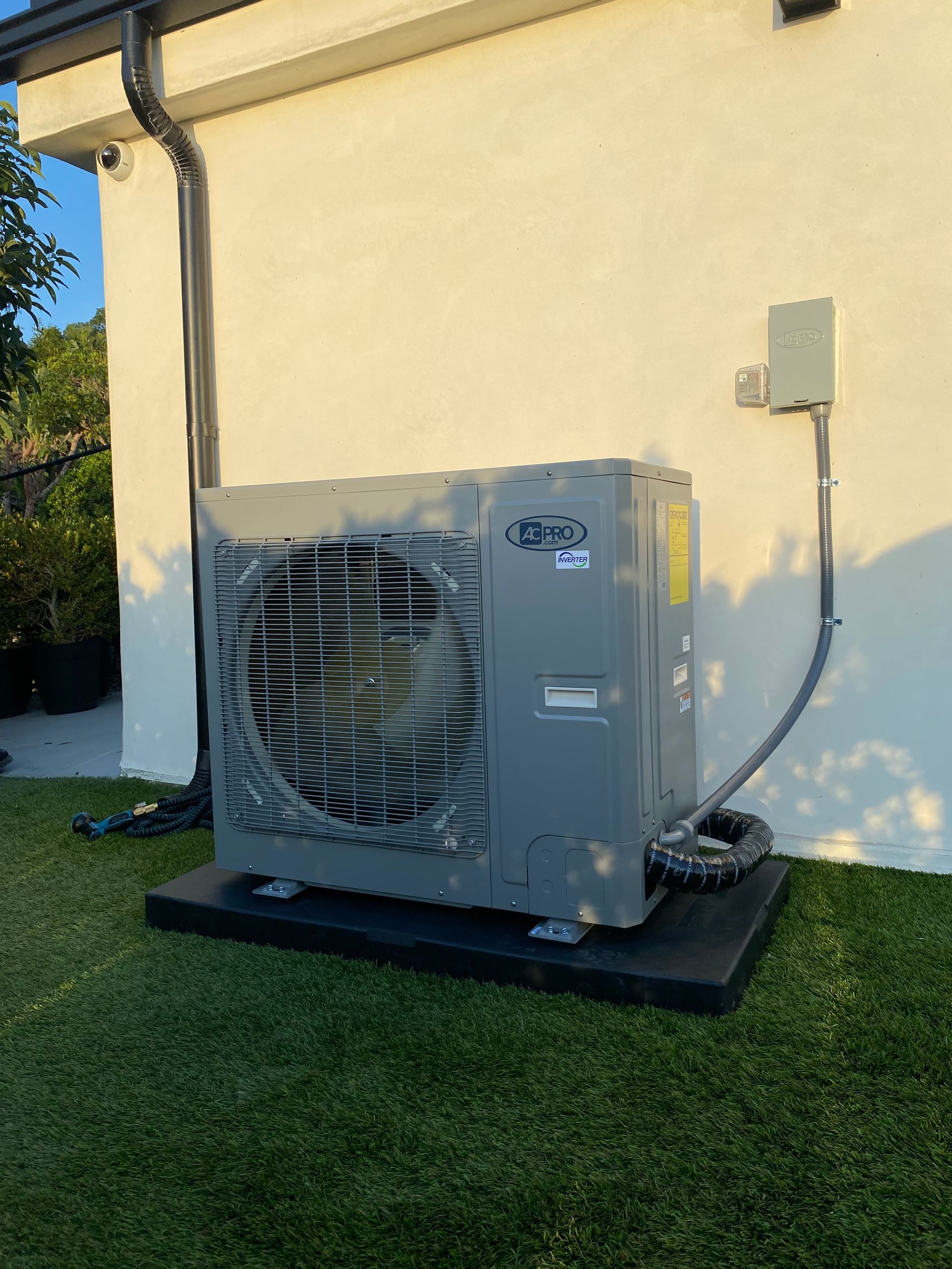 A large air conditioner is sitting on the side of a house.