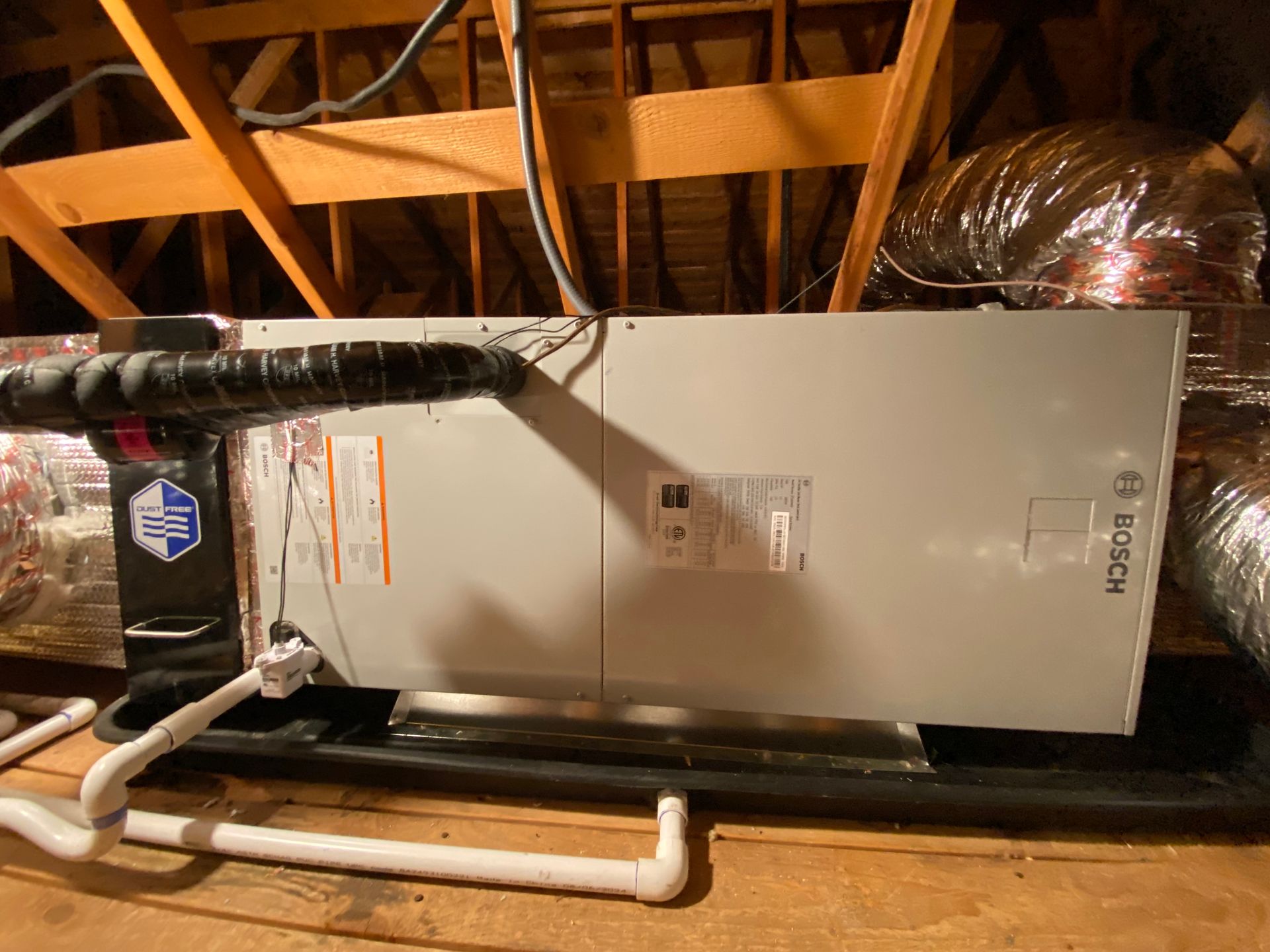 A bosch air conditioner is sitting in the attic of a house.