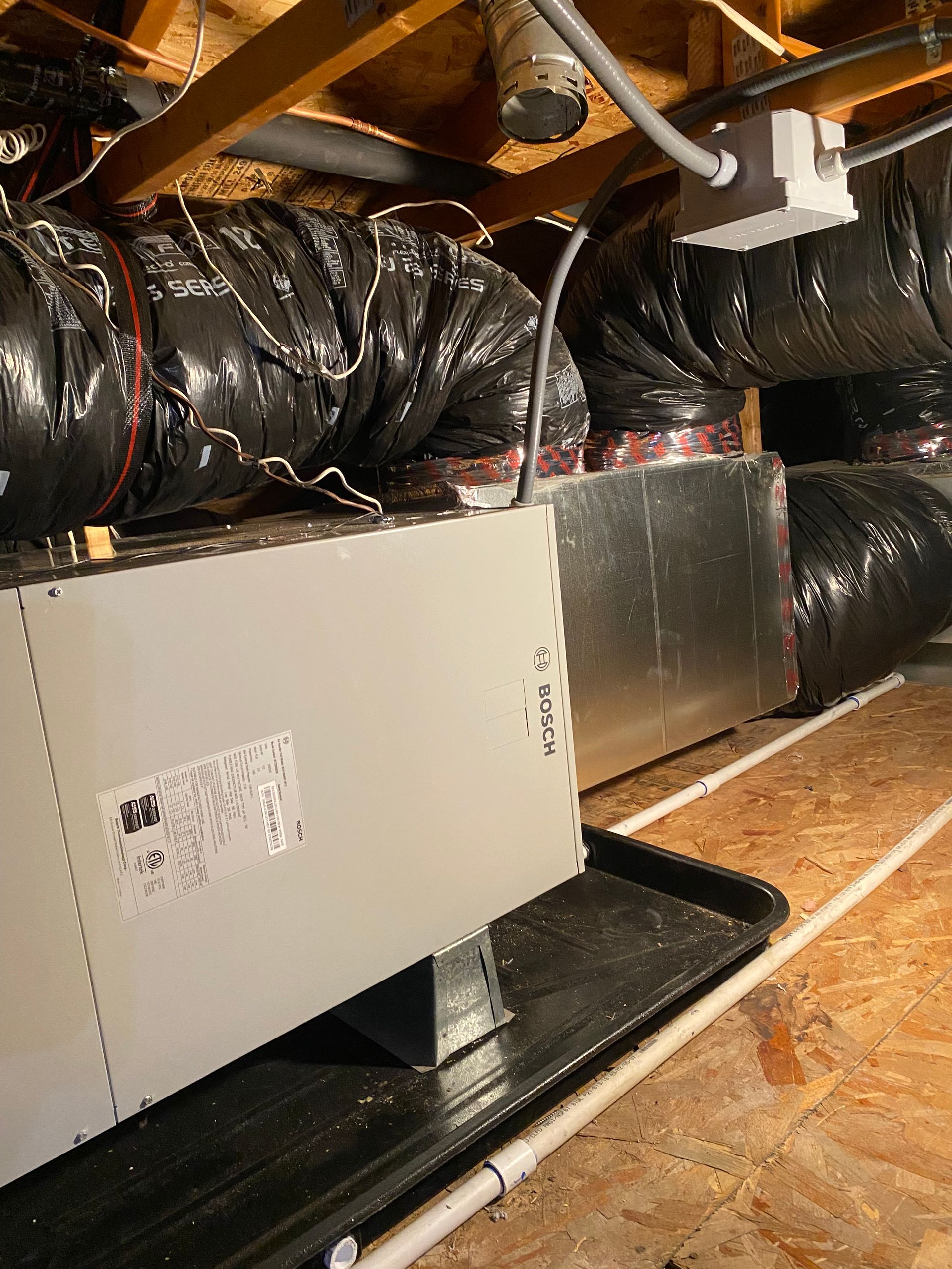 A bunch of ducts are hanging from the ceiling of a building.