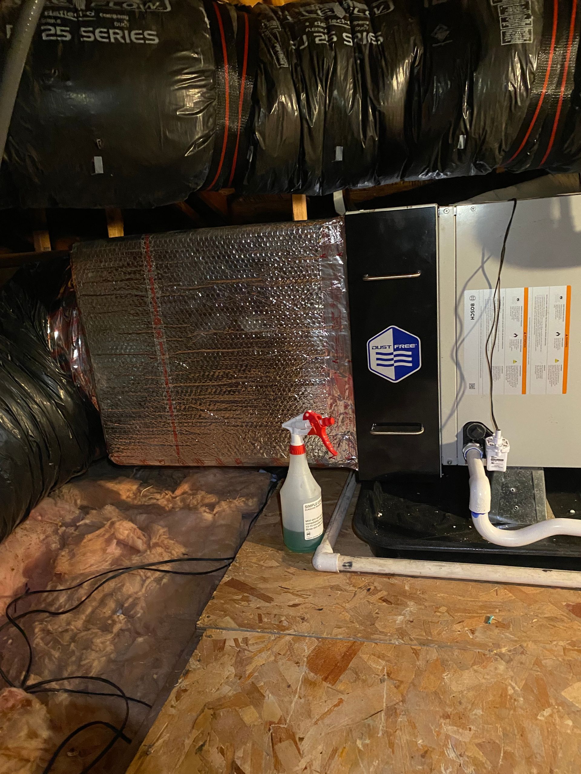 A spray bottle is sitting next to a box in a room.