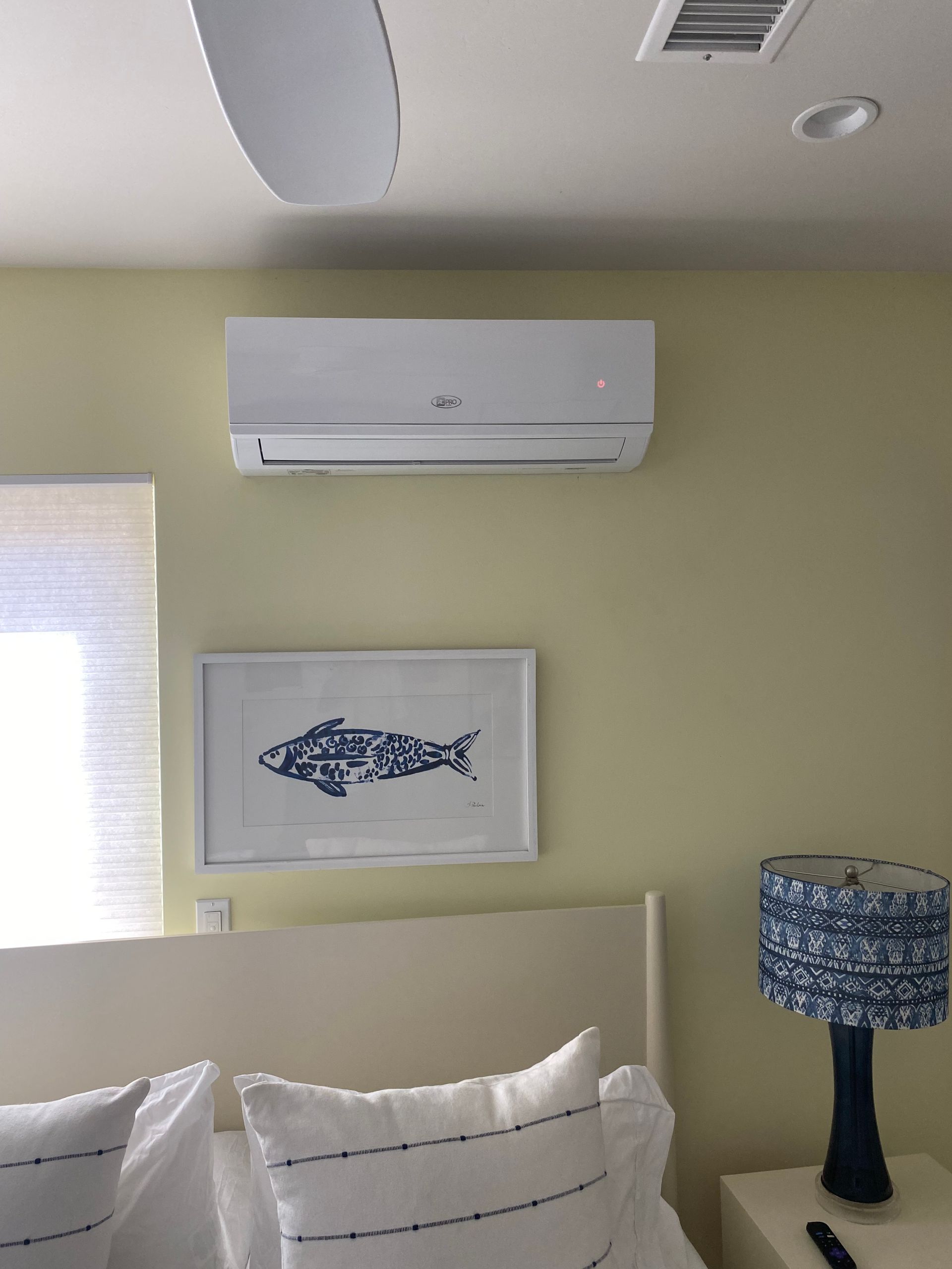 A bedroom with a picture of a fish on the wall above the bed