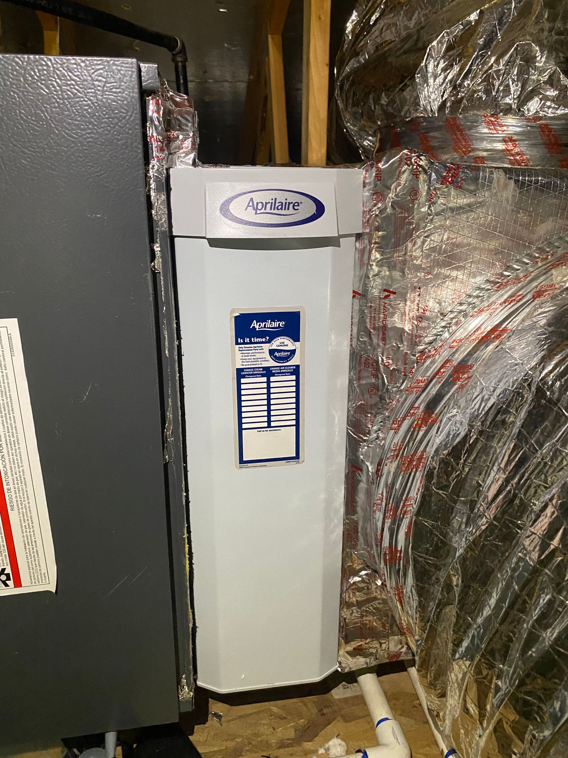 A white heater is sitting in a room with plastic wrapped around it.