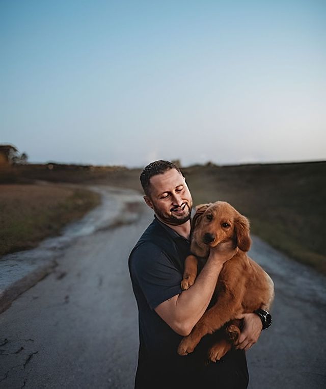 A Man is Holding a Puppy in his Arms on a Road | Springfield, MO | MMK9