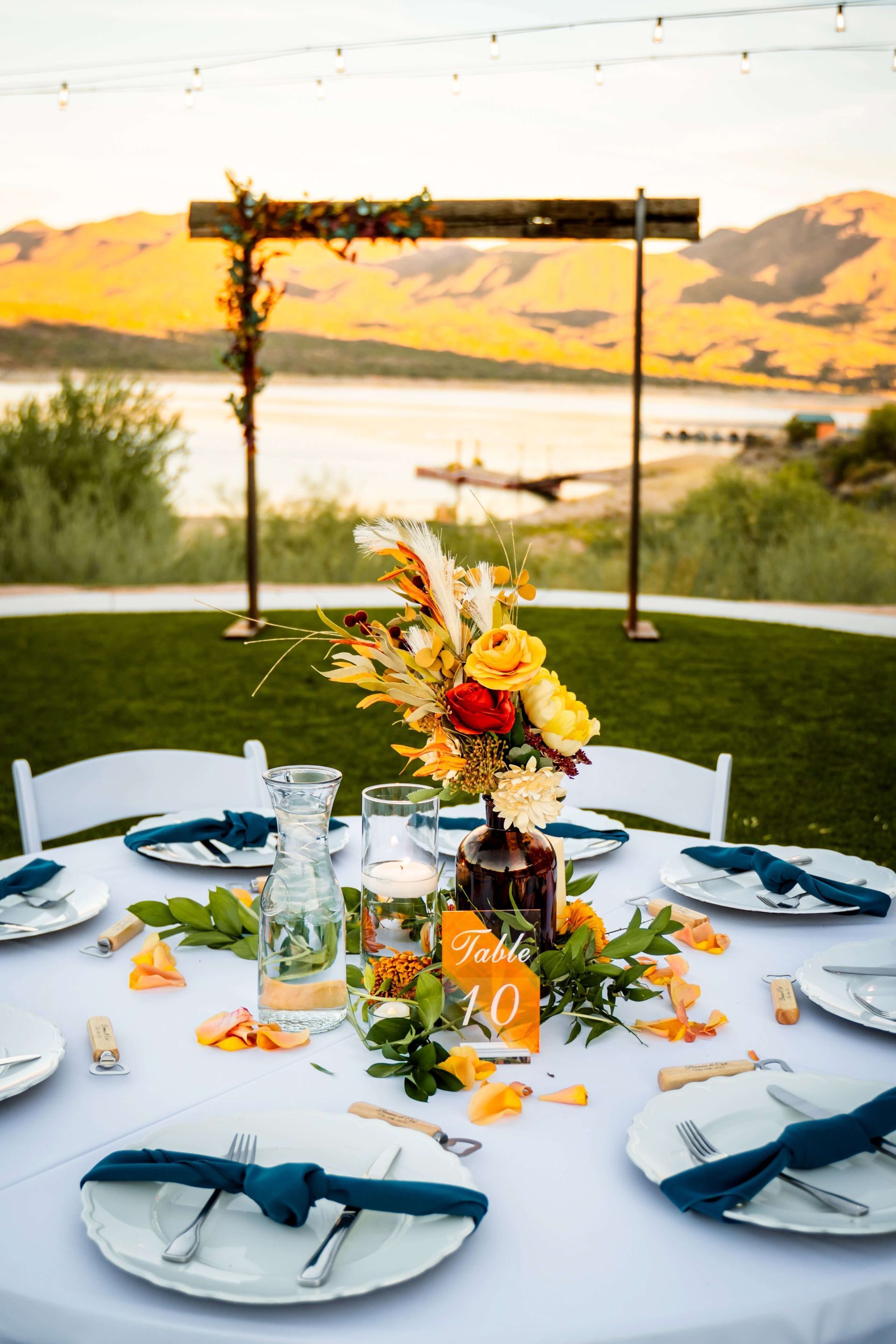 Lakeside wedding table set up in front of arch at Venue at the Cove