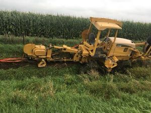 A bulldozer is digging a trench in the dirt.