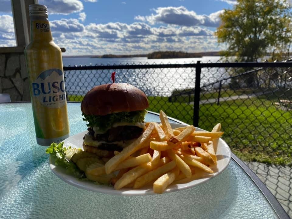 A hamburger and french fries on a plate next to a bliss light beer