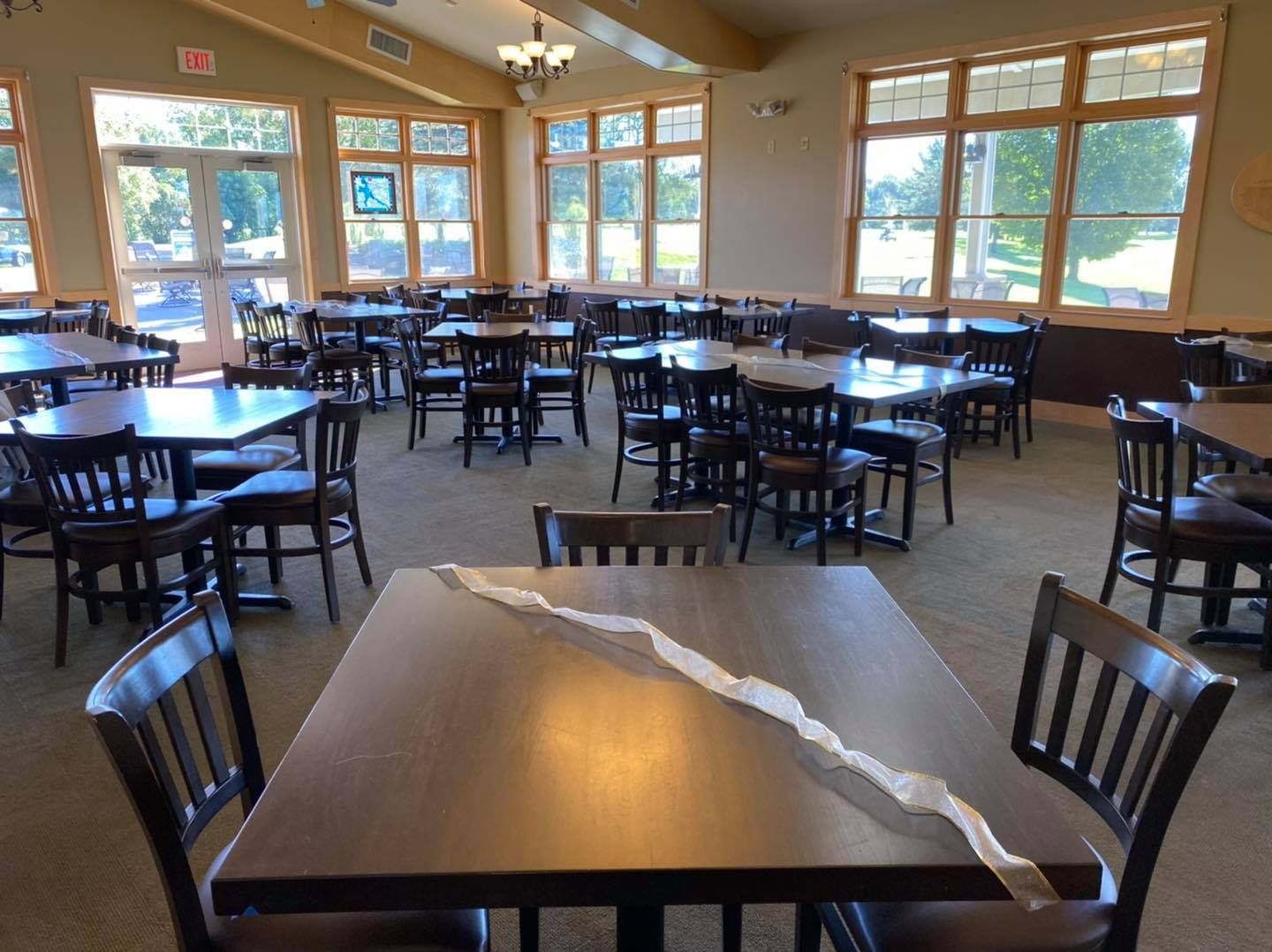 A restaurant with tables and chairs and a large window