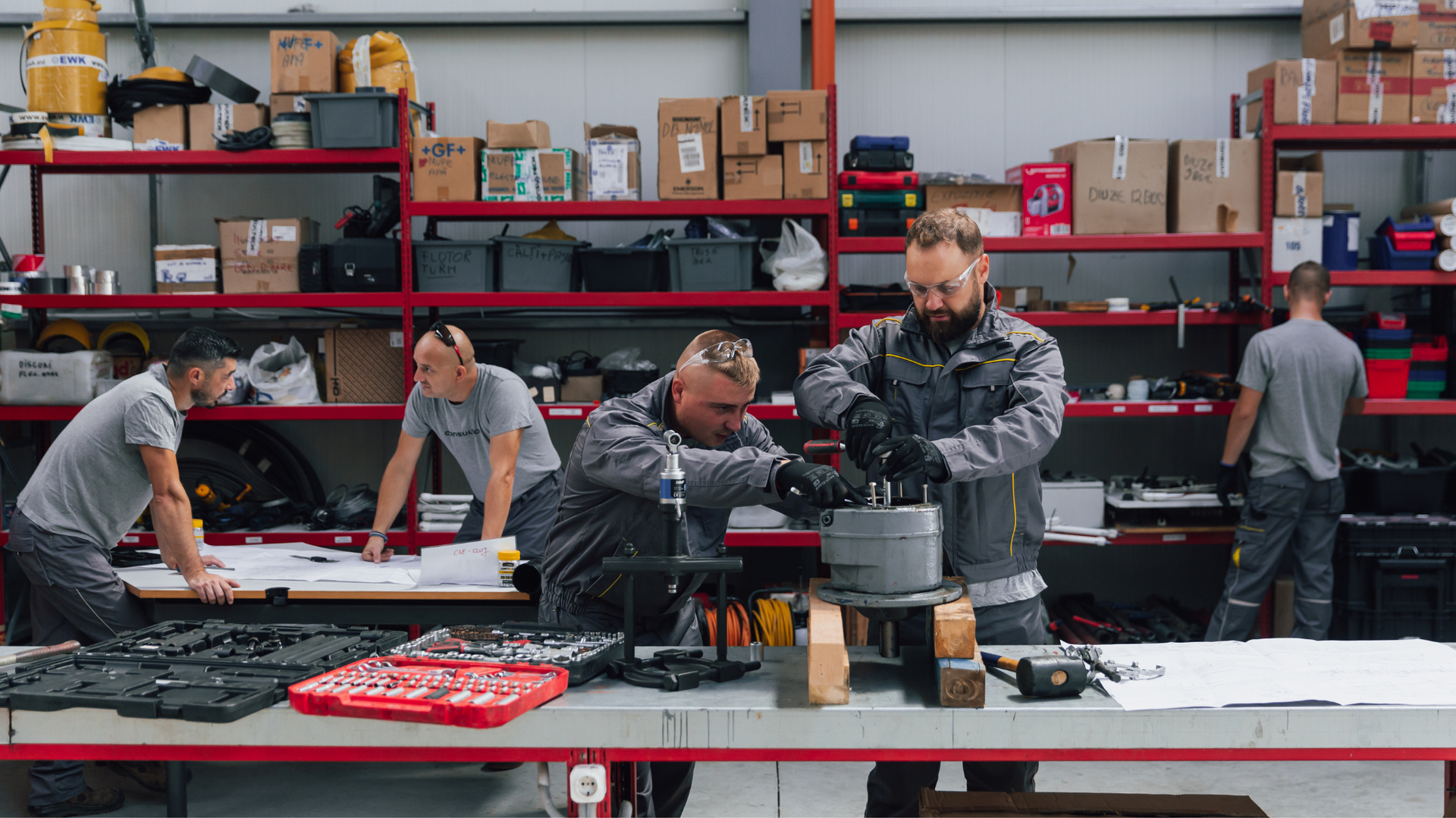 A group of men are working on a machine in a factory.