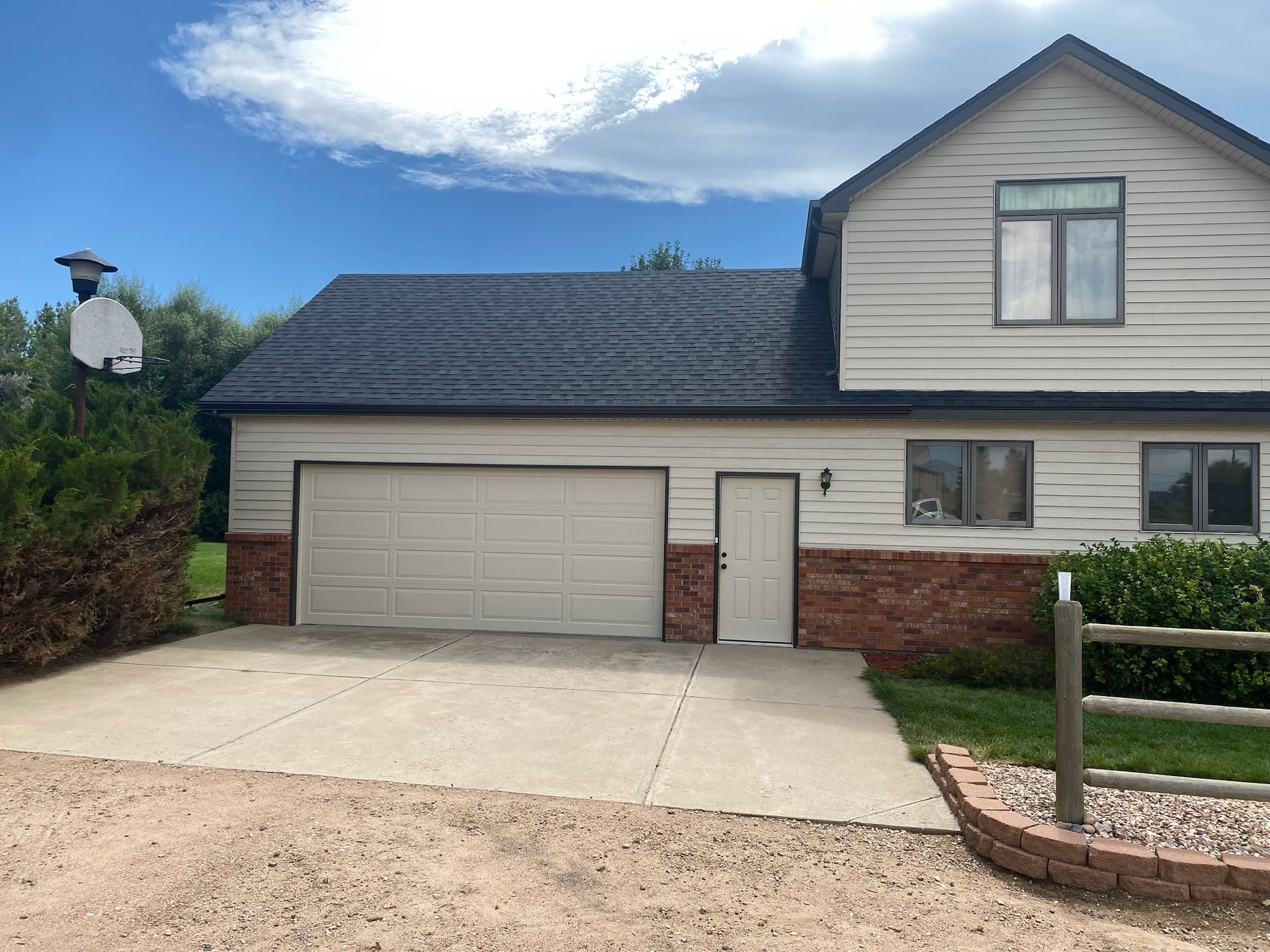 A house with a garage and a basketball hoop in front of it