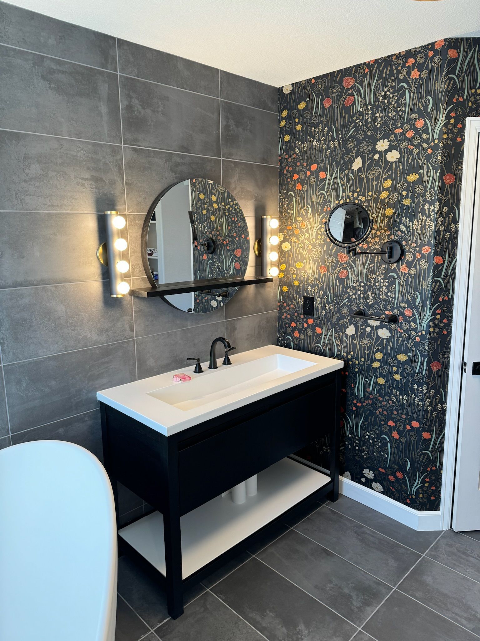 A bathroom with a sink , mirror and bathtub.