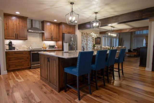 A kitchen with a large island and blue chairs.