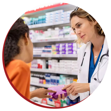 A female pharmacist is talking to a young girl in a pharmacy.