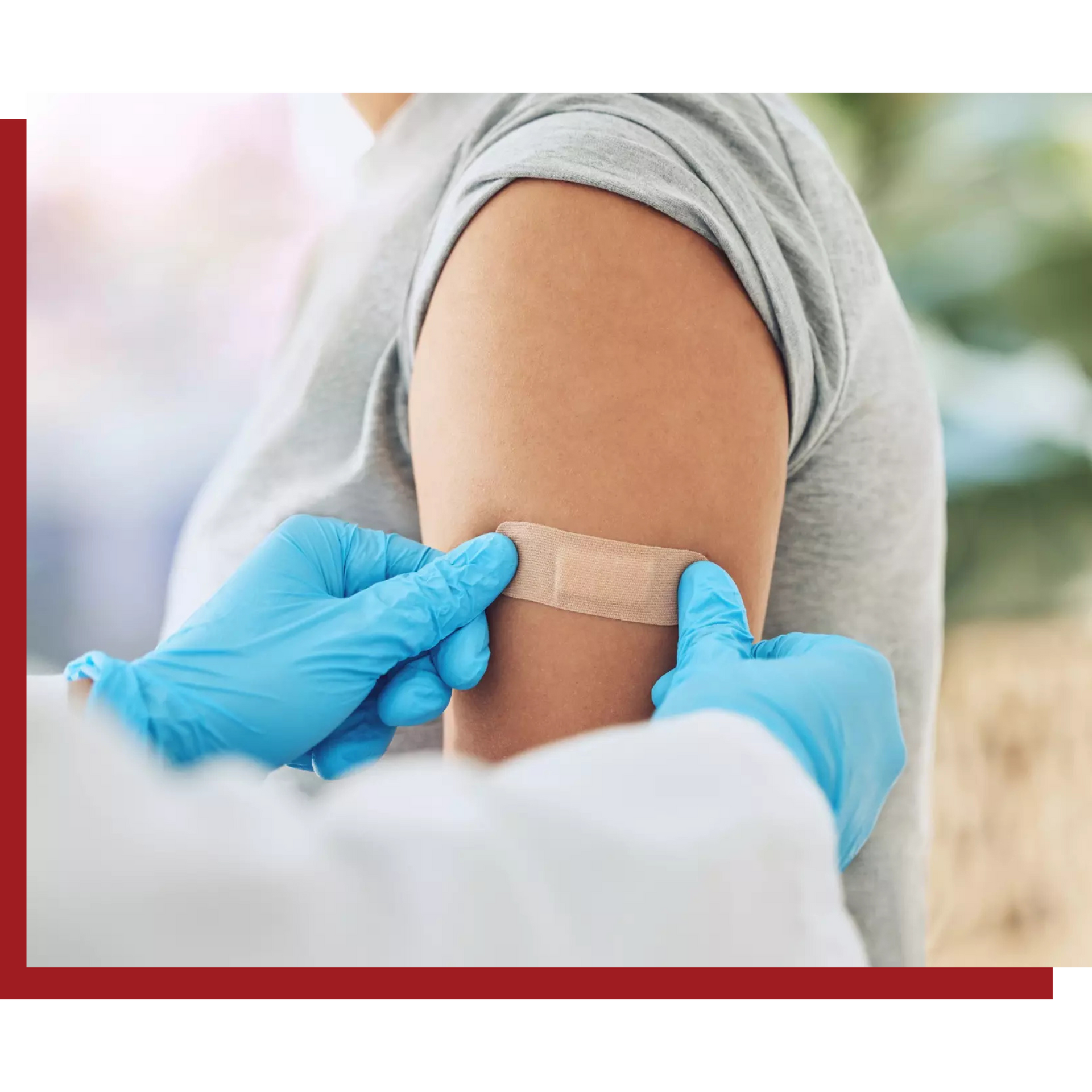 A person is getting a bandage on their arm after getting a vaccine.