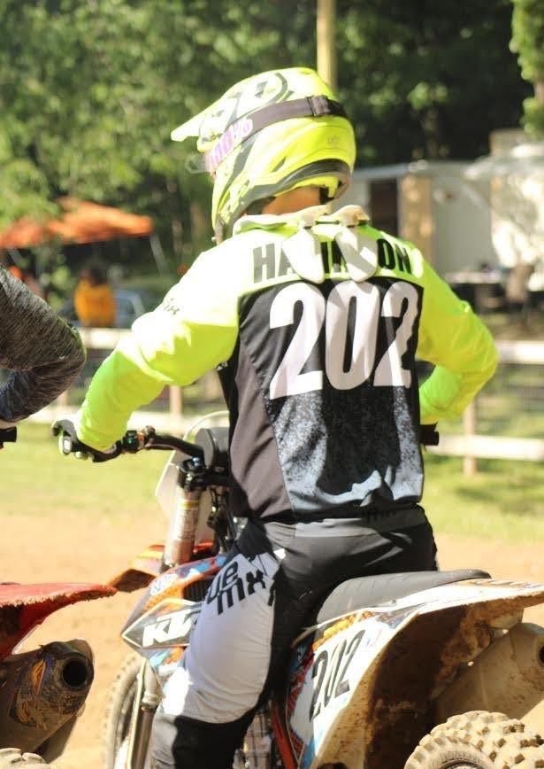 Motocross rider, back view, wearing yellow and black gear, number 202, on a KTM bike.