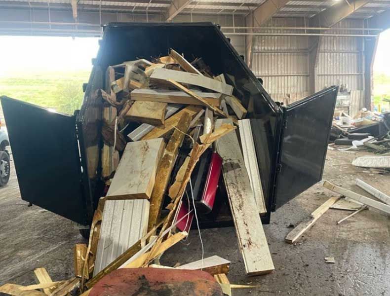 a dumpster filled with wood and metal is sitting in a warehouse