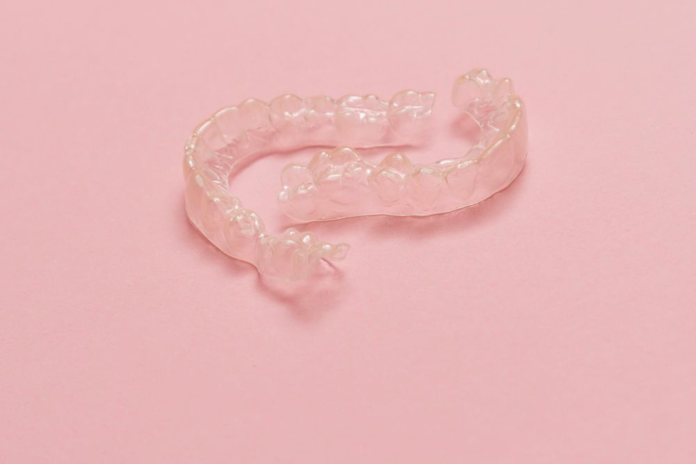 A Group of Mouth Guards of Different Colors Are Sitting on A Table — Peter McLennan Denture Clinic in Grafton, NSW