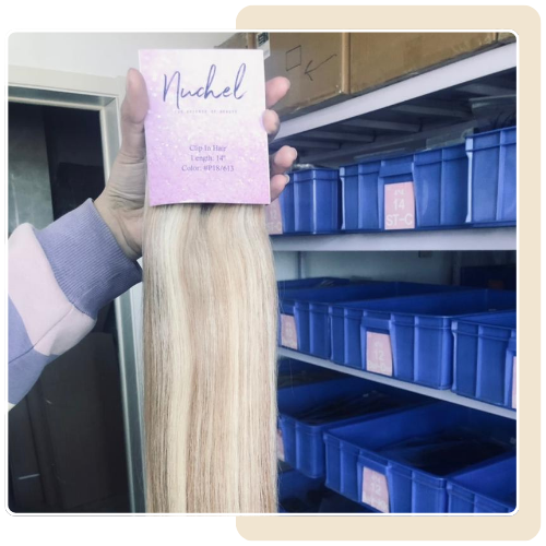 A person is holding a package of hair in front of a shelf.