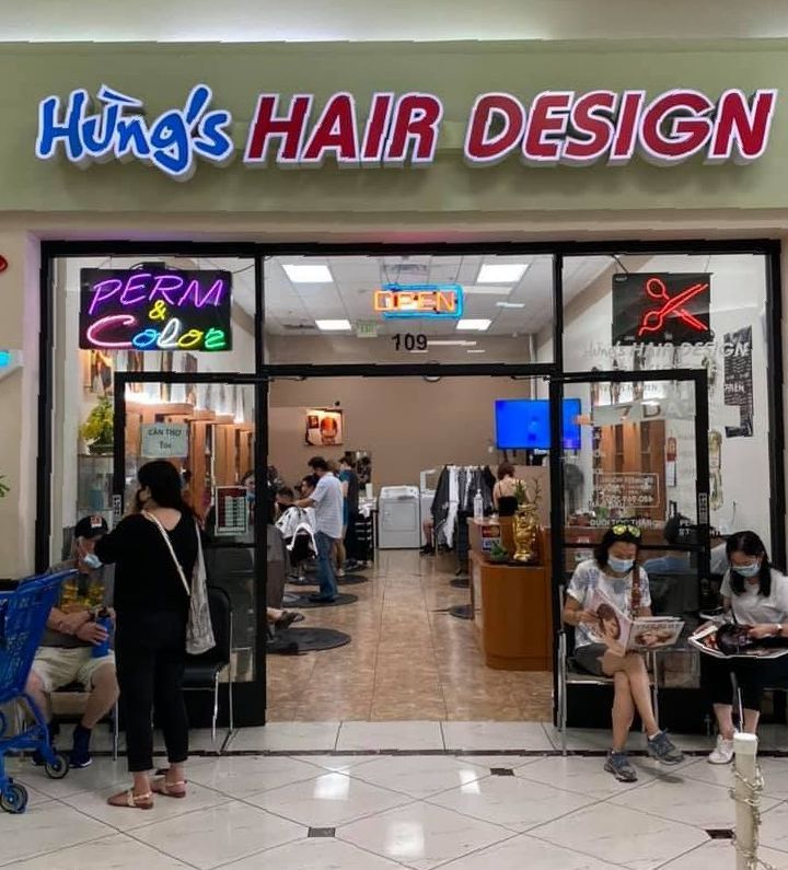 a group of people are standing outside of a hair salon .