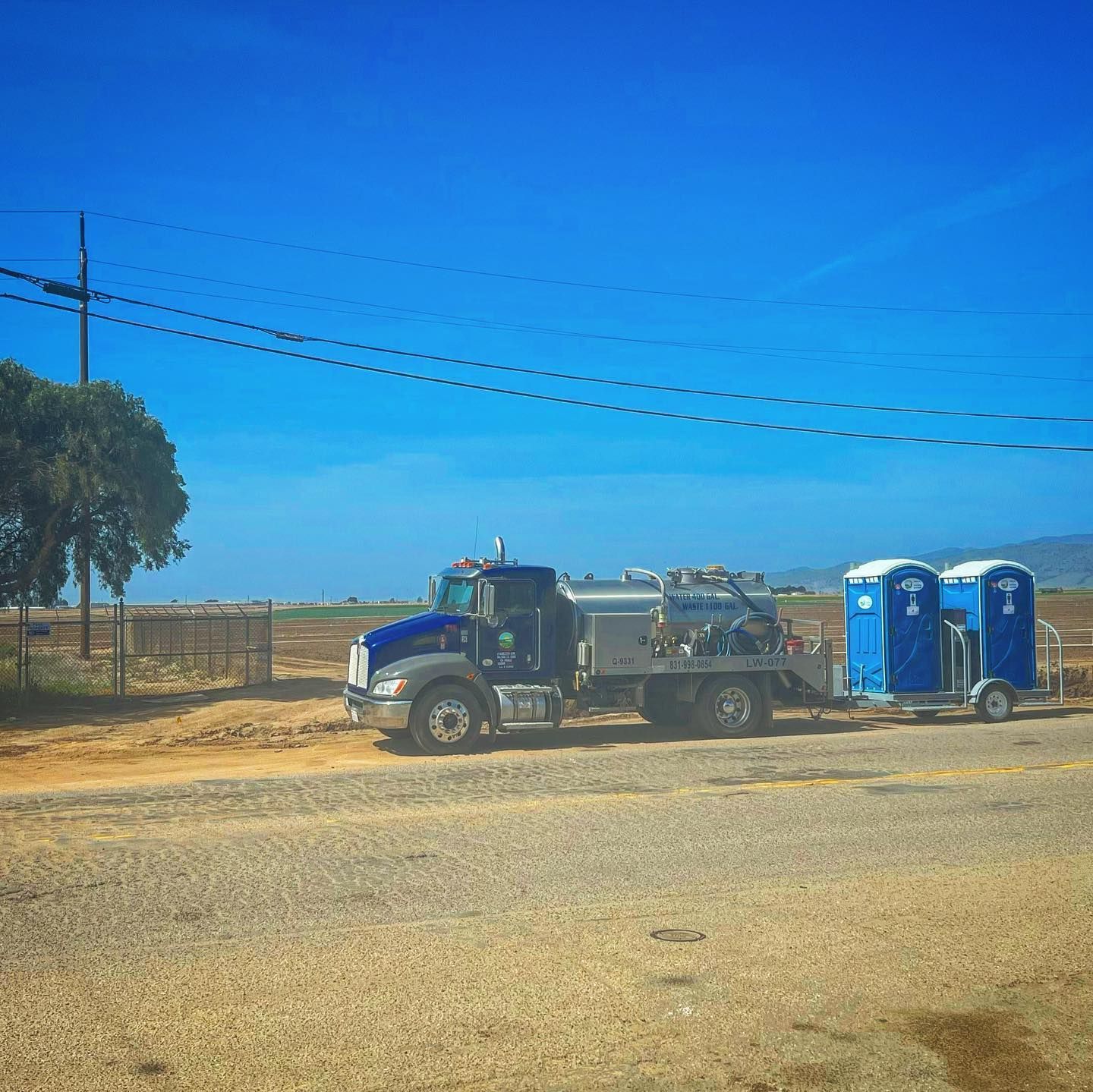 A truck with a trailer attached to it is parked on the side of the road.