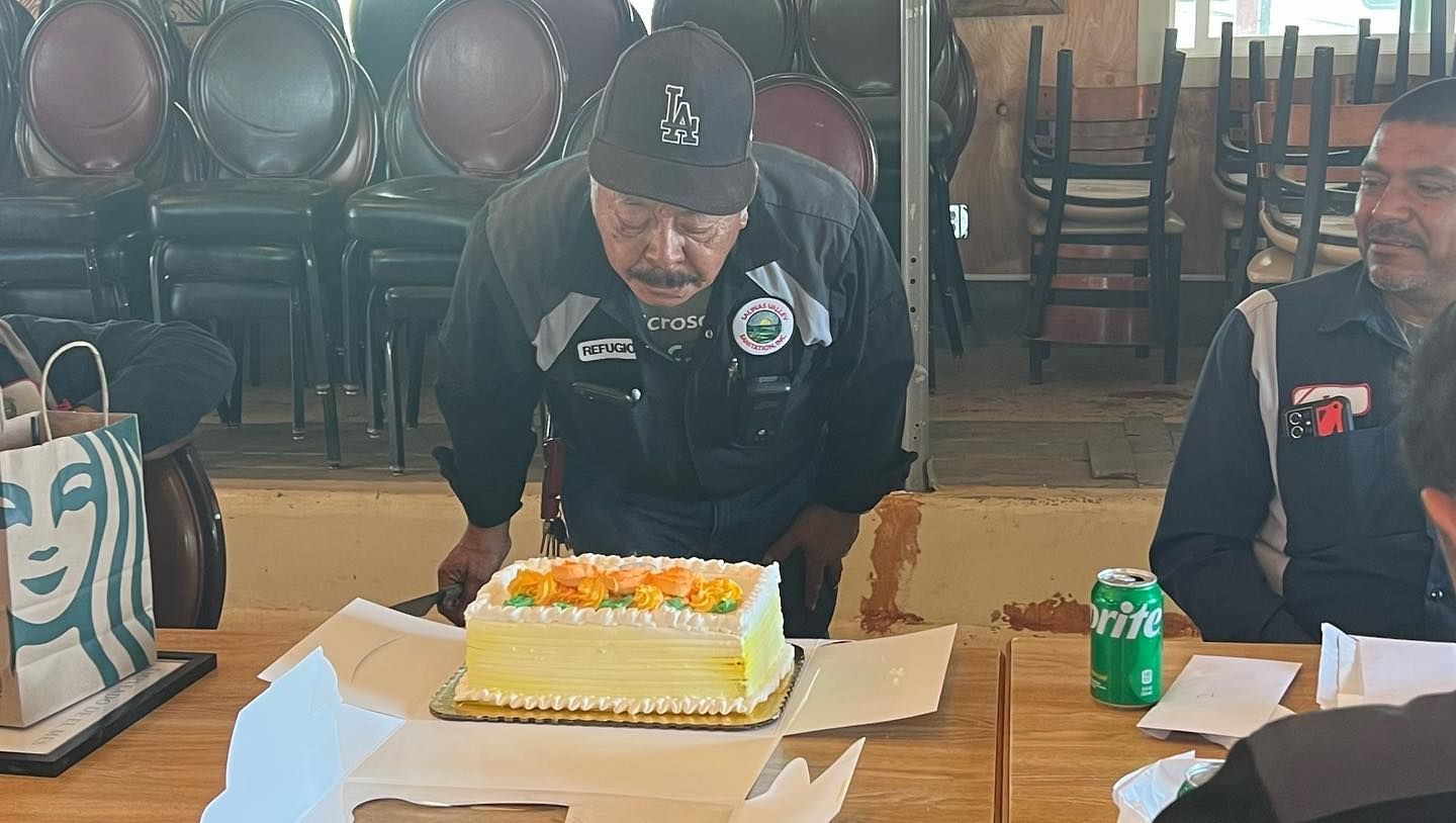 A man is standing in front of a cake on a table.
