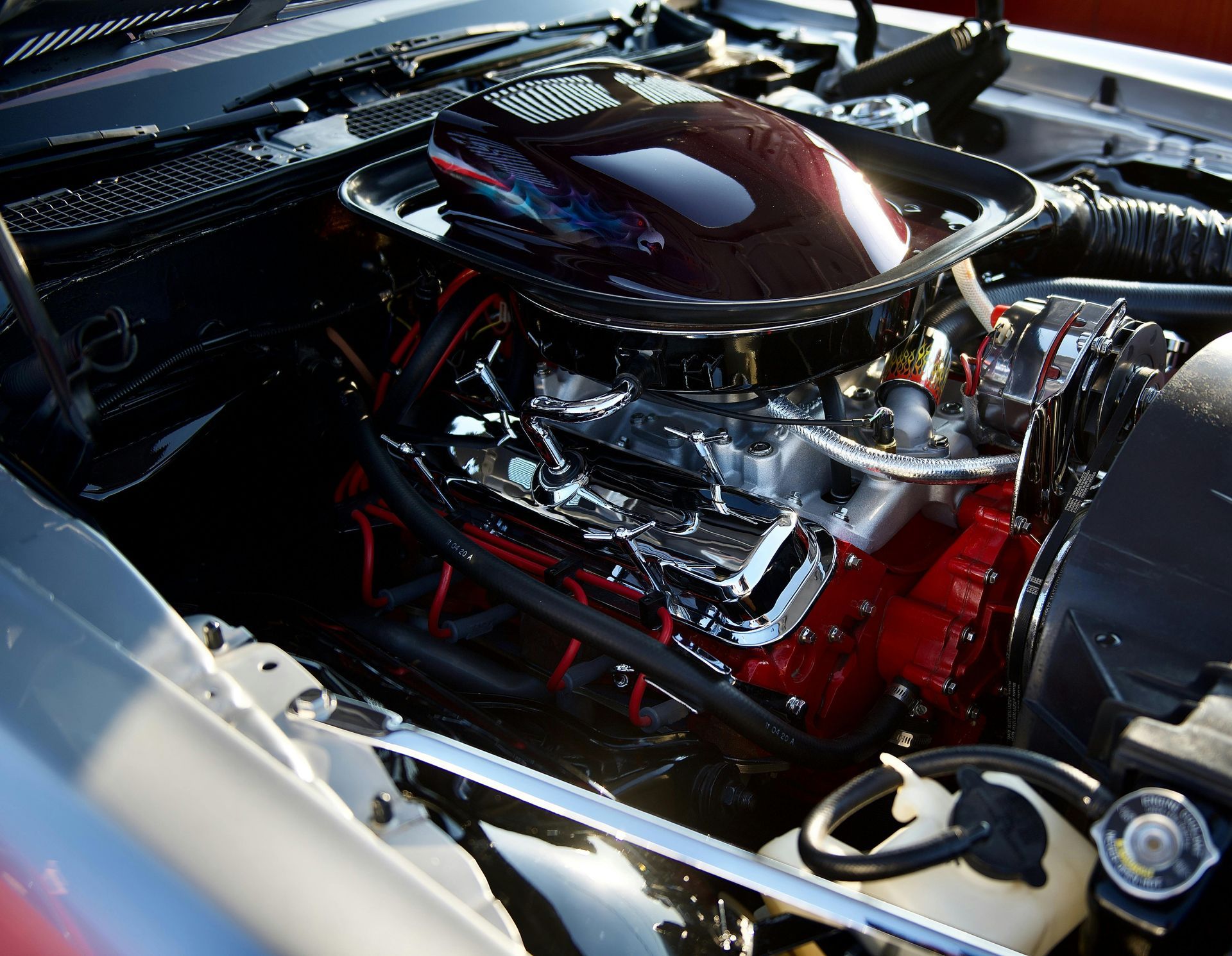 A close up of a car engine with the hood open