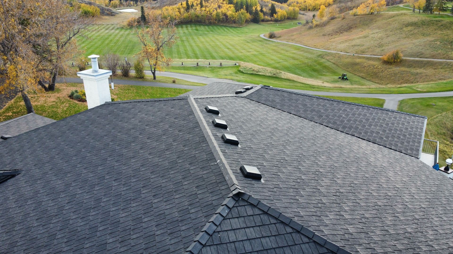 An aerial view of a roof with a golf course in the background.