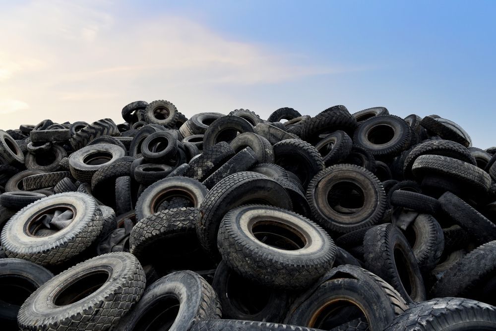 a pile of old tires against a blue sky