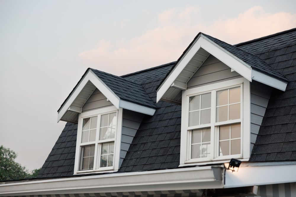 There are two windows on the roof of a house.