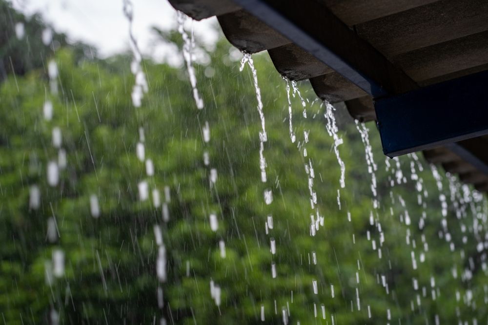 Rain is falling from the roof of a house.