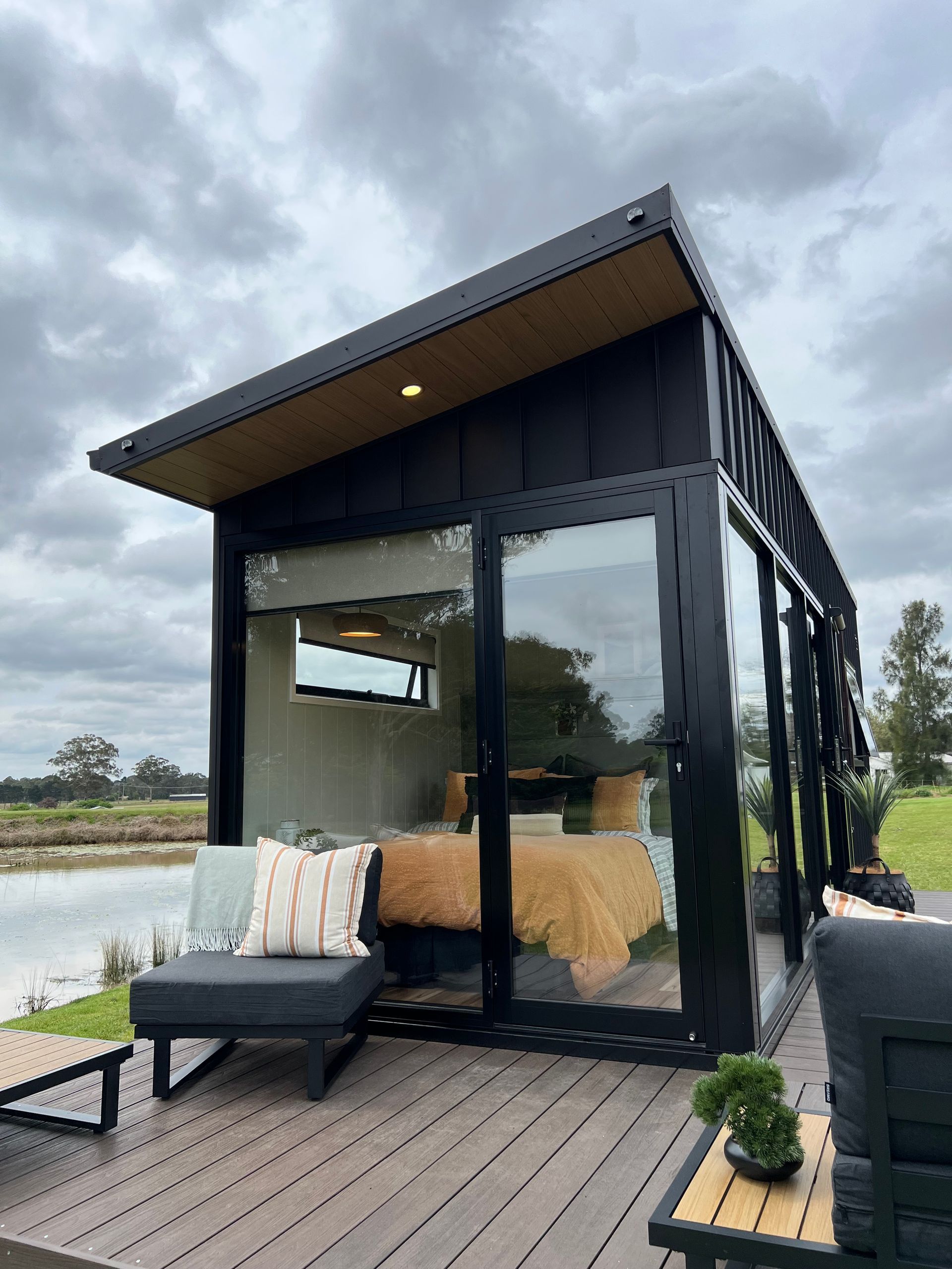 Small white kitchen with wood countertop, black fixtures, and a window.