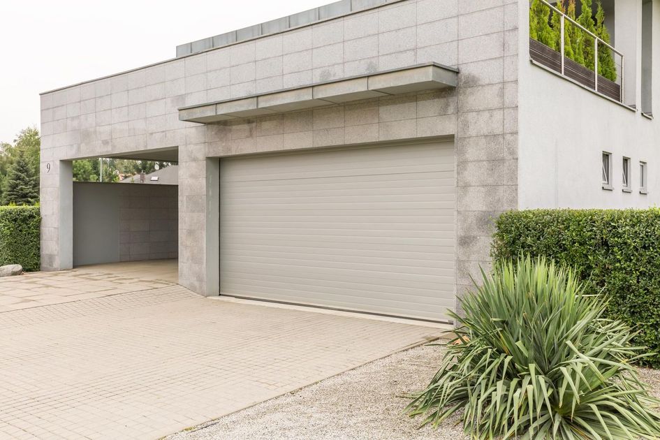 A large white house with a garage door and a driveway.