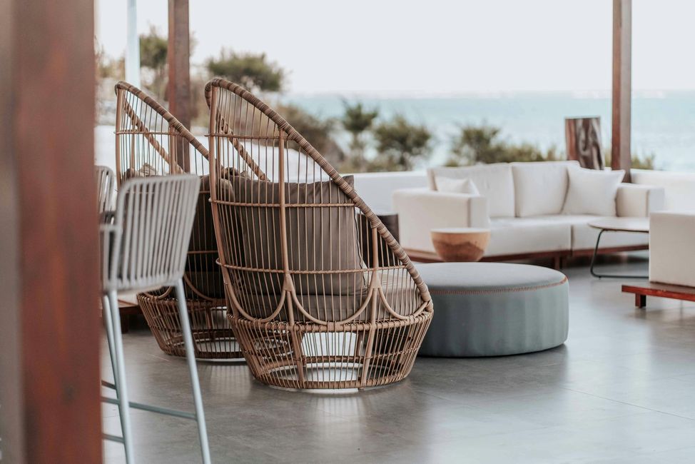 A couple of wicker chairs sitting next to each other in a living room.