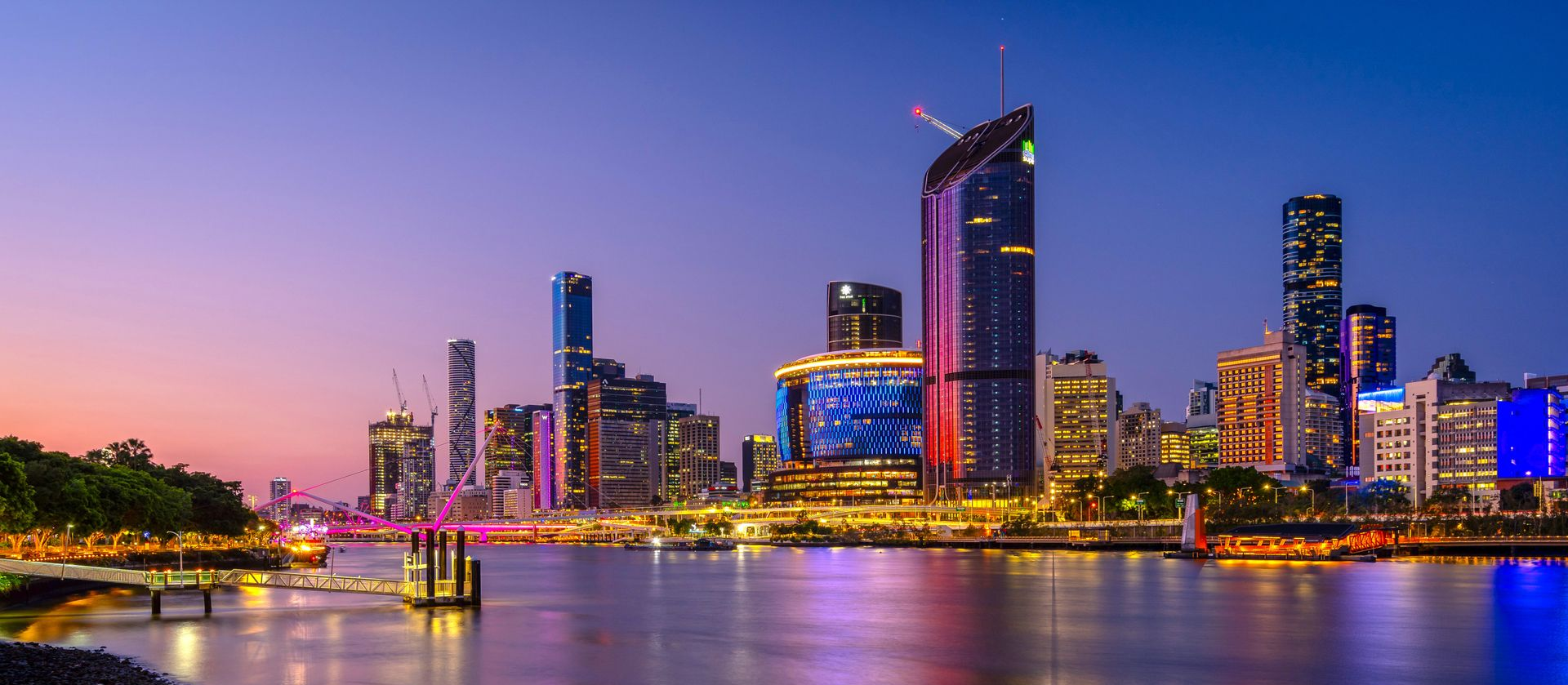Silhouetted figures on beach, facing sunset, with warm golden light reflecting on the water and sand.