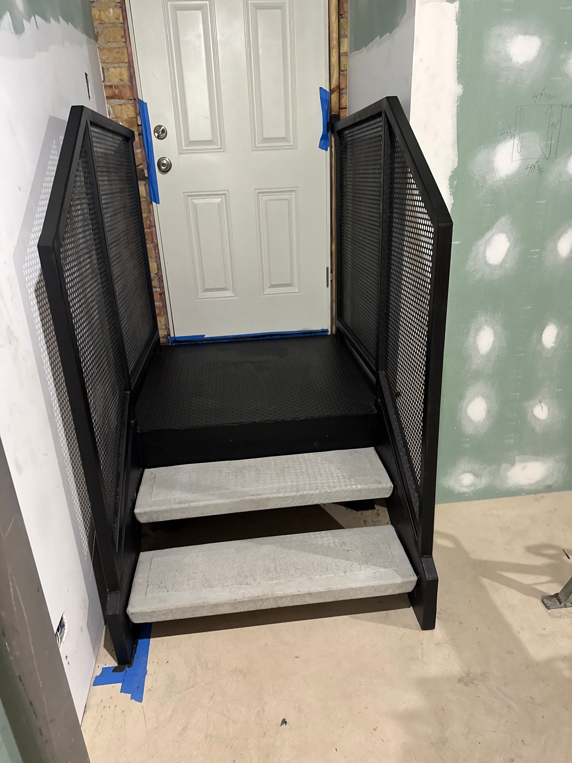 A set of stairs leading up to a door in a room.