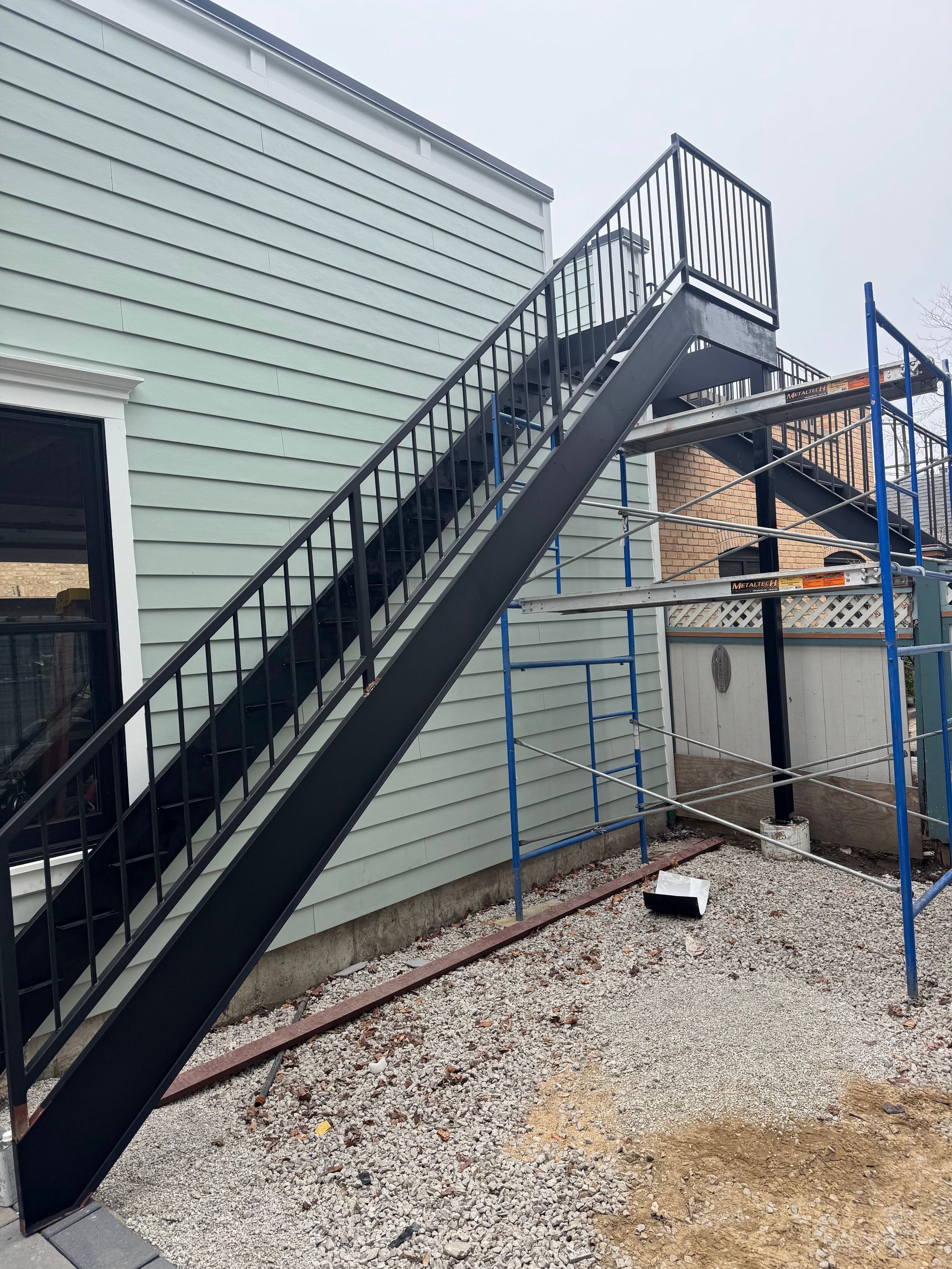 A black staircase is being built on the side of a building.
