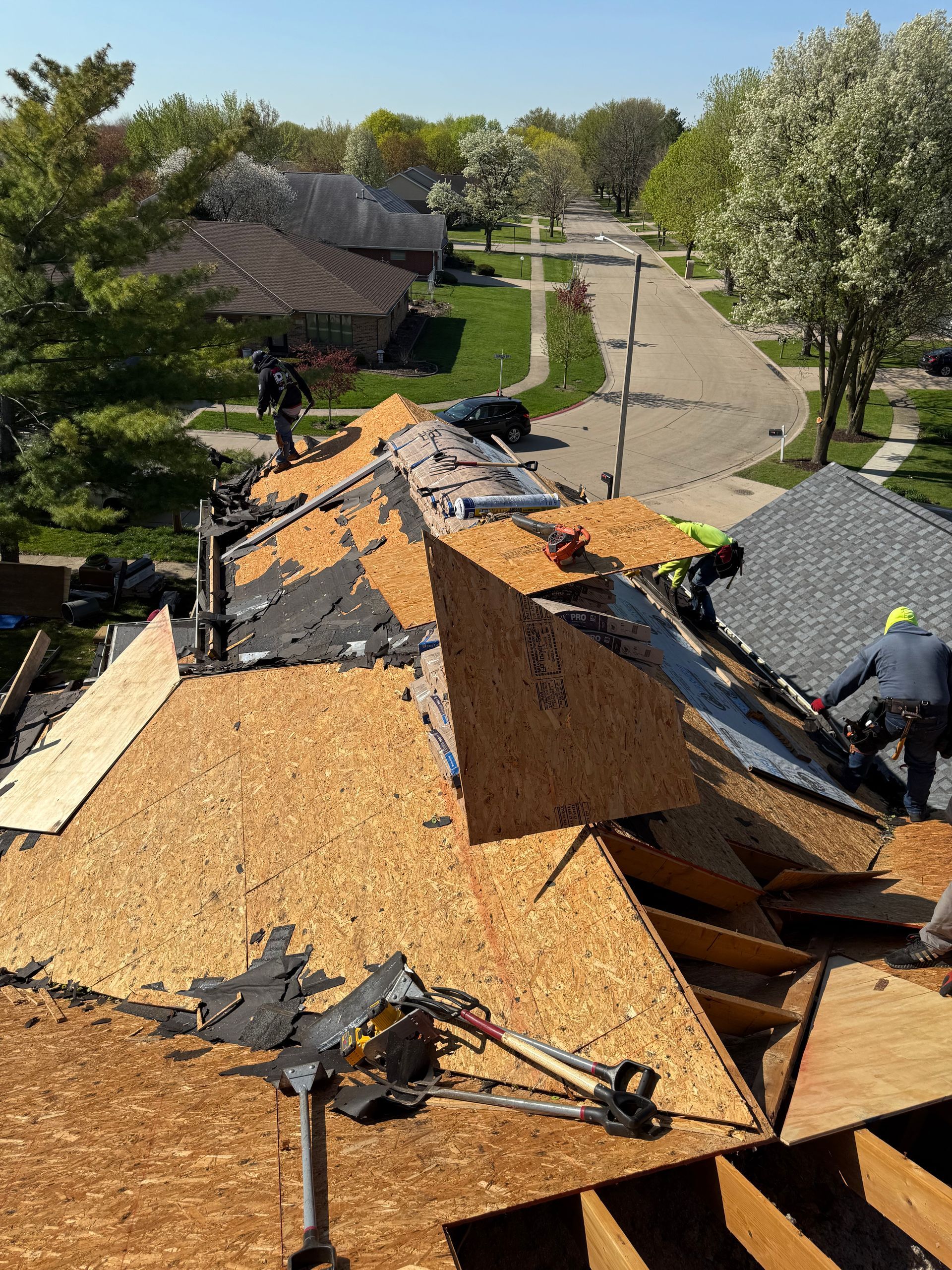 A group of men are working on the roof of a house.