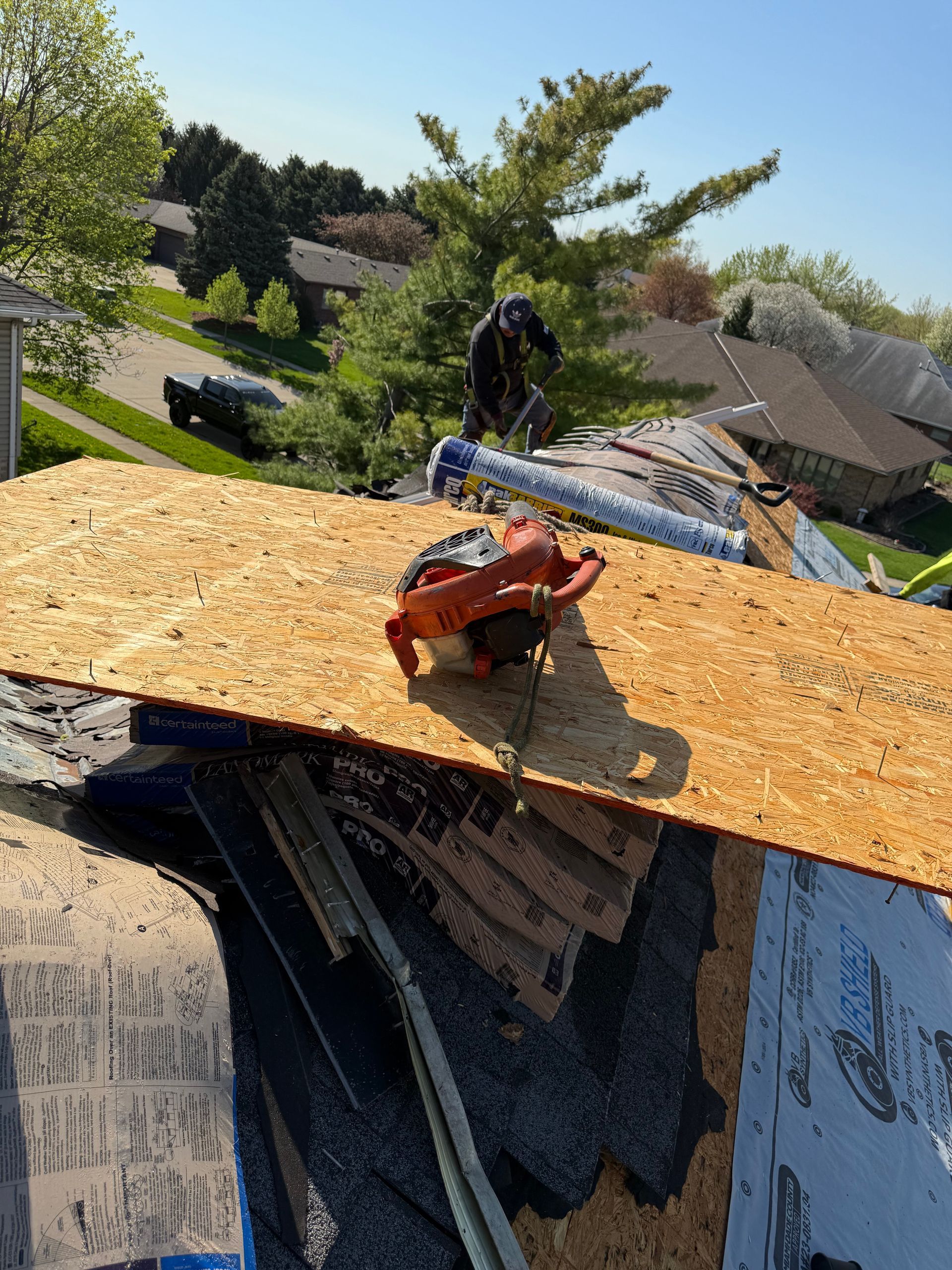 A man is working on the roof of a house.