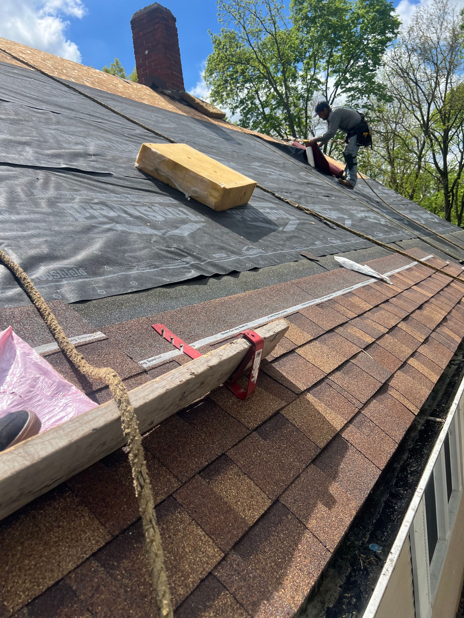 A man is working on the roof of a house.