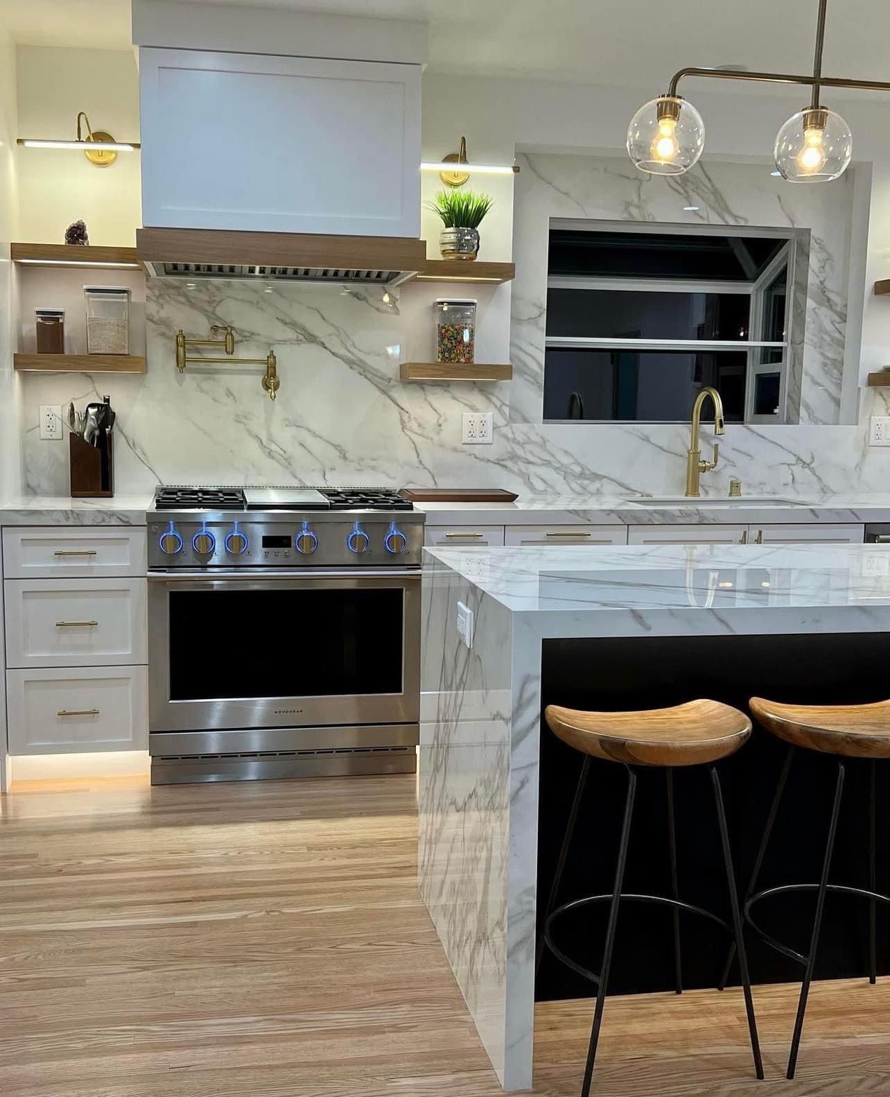 A kitchen with stainless steel appliances and marble counter tops