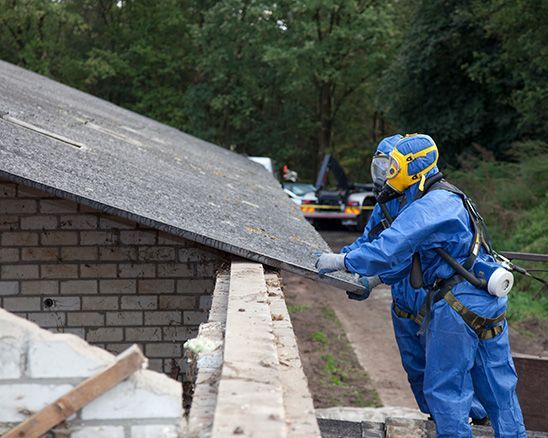 a man in a blue protective suit is working on a roof .